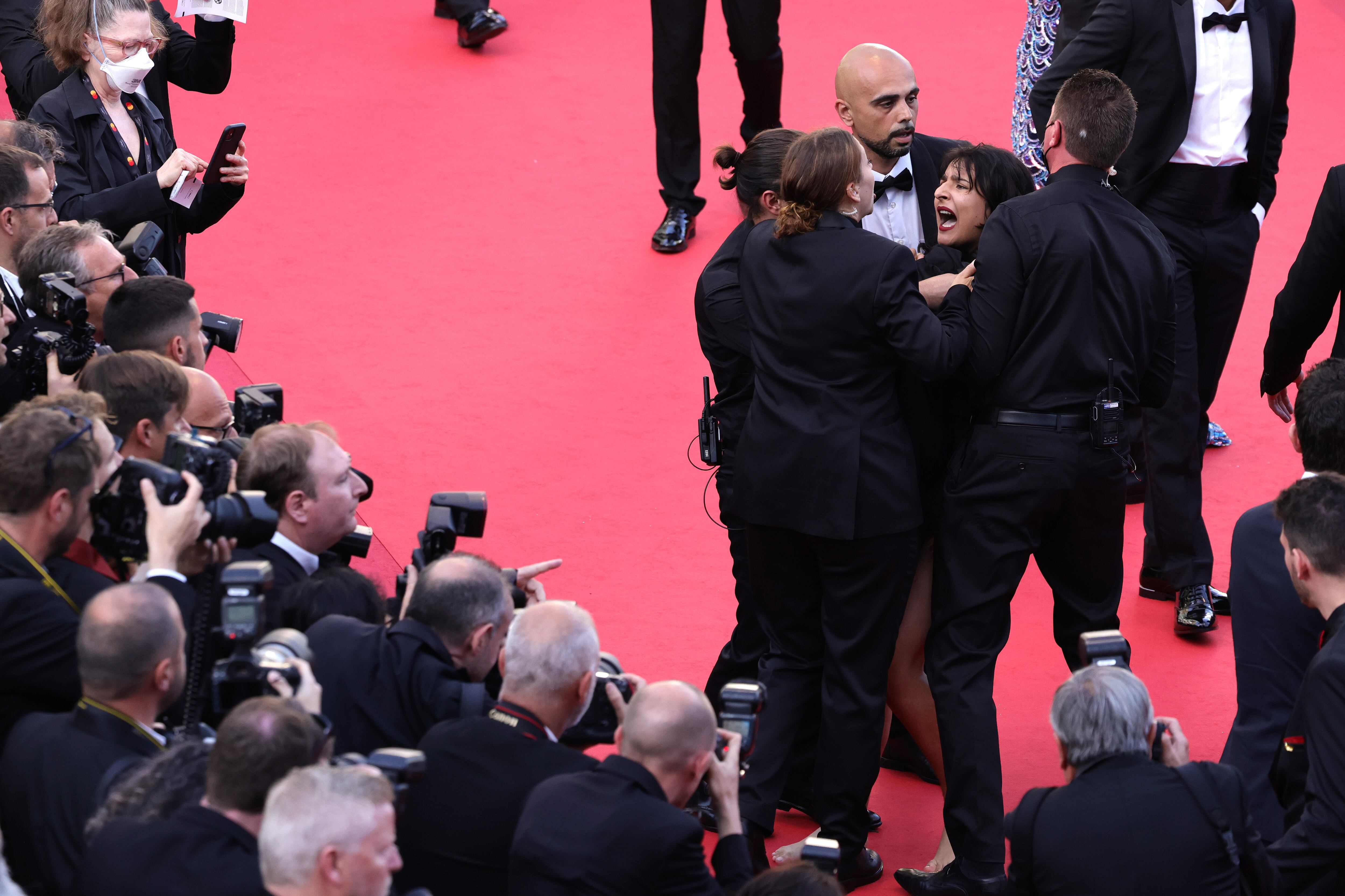 CANNES, FRANCE - MAY 20: Security remove a protester from the red carpet during the "Three Thousand Years Of Longing (Trois Mille Ans A T'Attendre)" Red Carpet during the 75th annual Cannes film festival at Palais des Festivals on May 20, 2022 in Cannes, France. (Photo by Andreas Rentz/Getty Images)