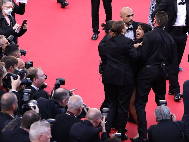 CANNES, FRANCE - MAY 20: Security remove a protester from the red carpet during the &quot;Three Thousand Years Of Longing (Trois Mille Ans A T&#039;Attendre)&quot; Red Carpet during the 75th annual Cannes film festival at Palais des Festivals on May 20, 2022 in Cannes, France. (Photo by Andreas Rentz/Getty Images)