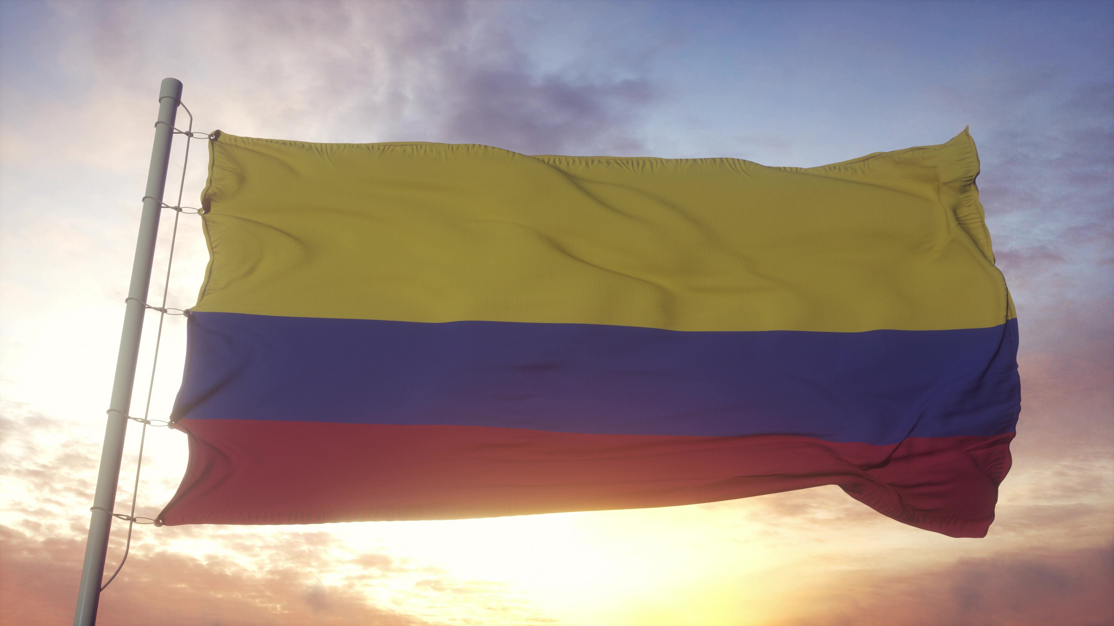 Flag of Colombia waving in the wind, sky and sun background. 3d rendering.