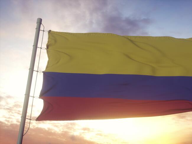 Flag of Colombia waving in the wind, sky and sun background. 3d rendering.