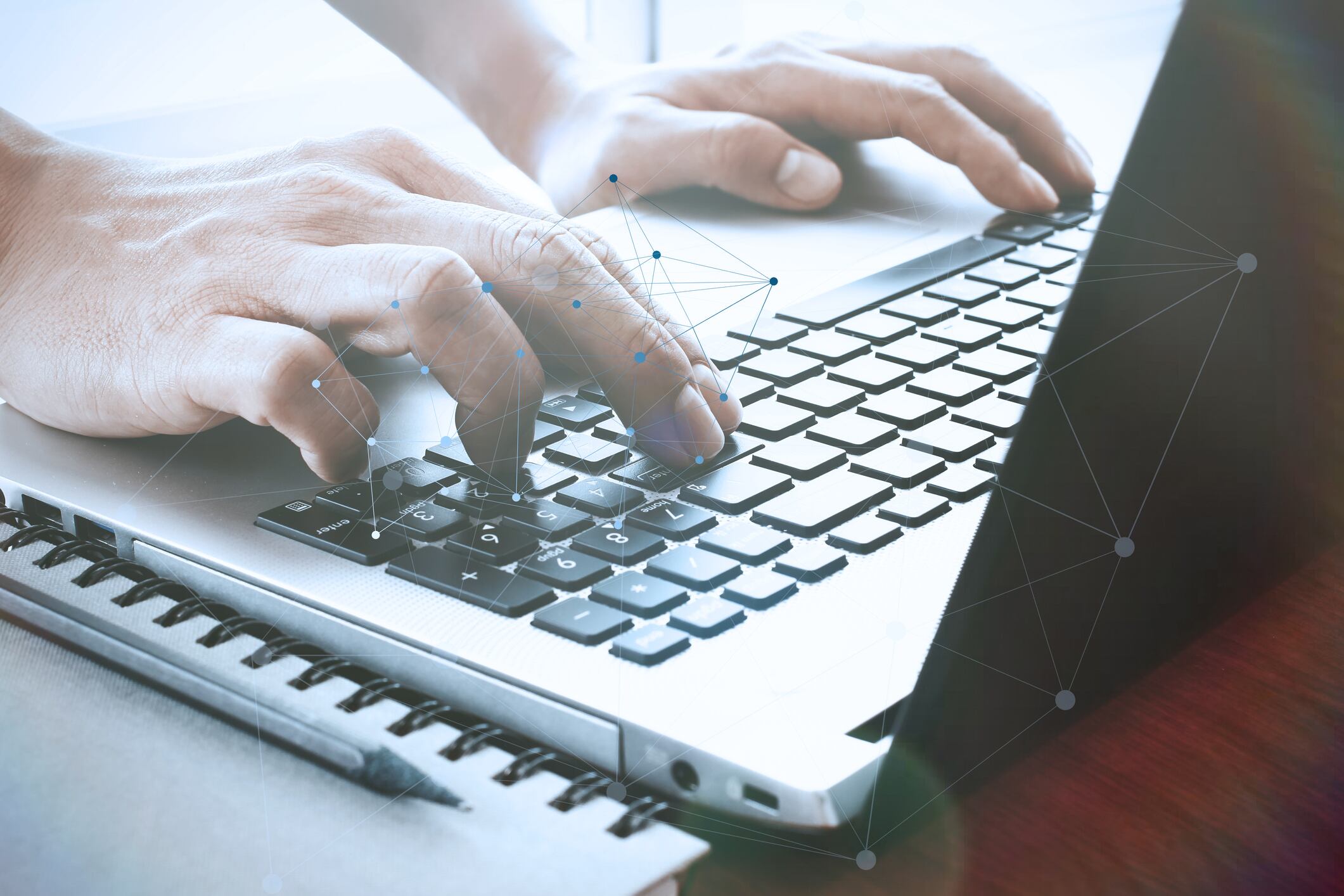 designer hand working with digital tablet and laptop and notebook stack and eye glass on wooden desk in office with social media diagram