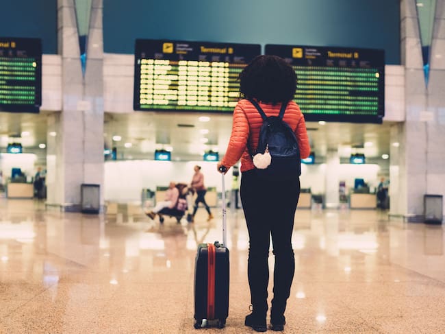 Young woman at the airport checking for the flight