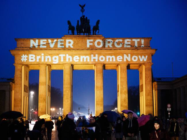 Berlin (Germany), 26/02/2025.- People stand in front of the Brandenburg Gate, illuminated in orange colors and reads 'Never Forget! #BringThemHomeNow', in Berlin, Germany, 26 February 2025. The protest was held to honor the lives of killed Israeli hostages of the family Bibas and to protest against Hamas terror. The bodies of four Israeli hostages, including those of Shiri Bibas and her young sons Ariel and Kfir, were returned to Israel on 20 February as part of the ongoing Gaza ceasefire deal between Israel and Hamas. (Protestas, Alemania) EFE/EPA/CLEMENS BILAN
