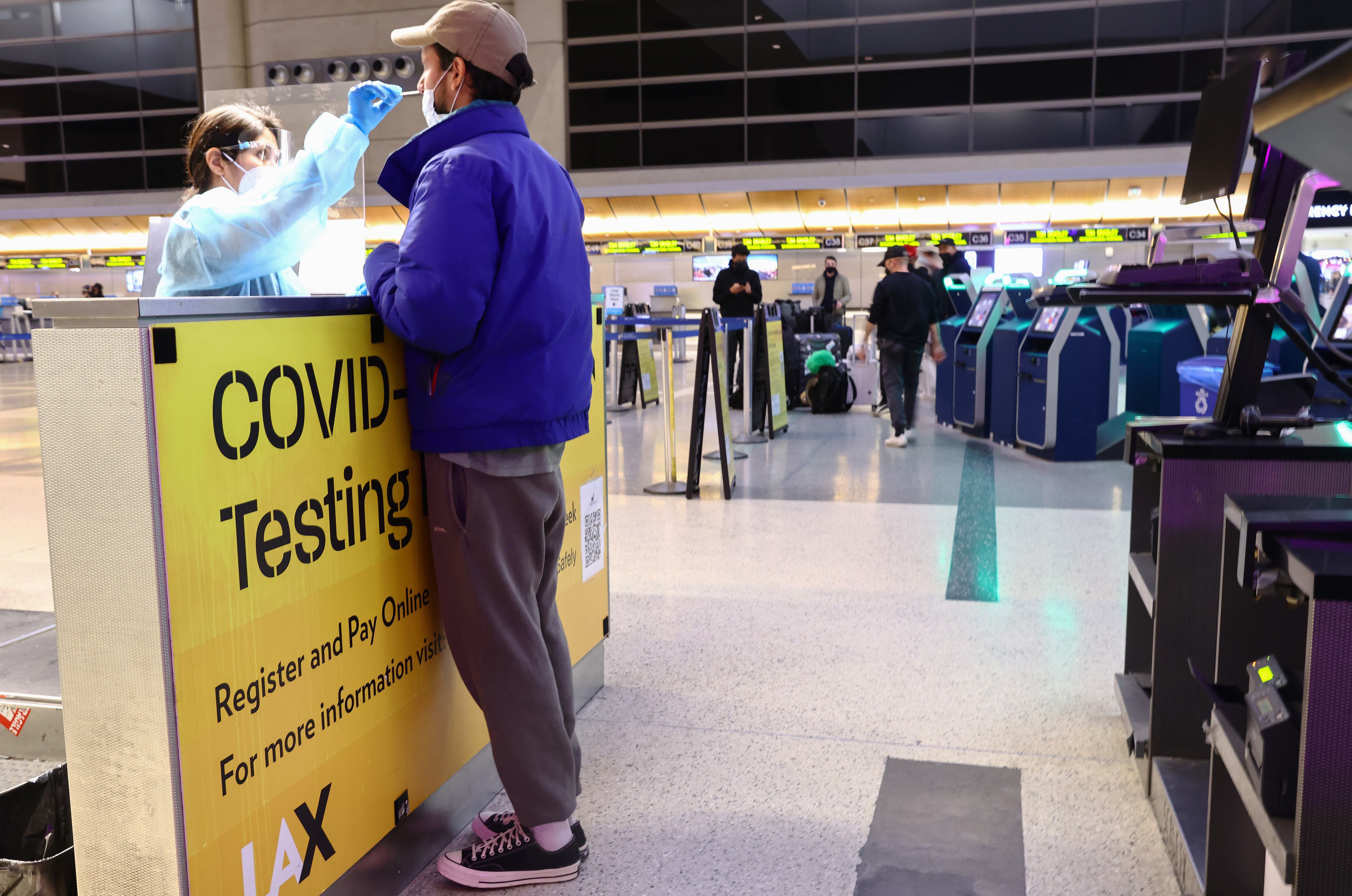LOS ANGELES, CALIFORNIA - DECEMBER 01: A person is tested for COVID-19 inside the Tom Bradley International Terminal at Los Angeles International Airport (LAX) on December 01, 2021 in Los Angeles, California. (Photo by Mario Tama/Getty Images)