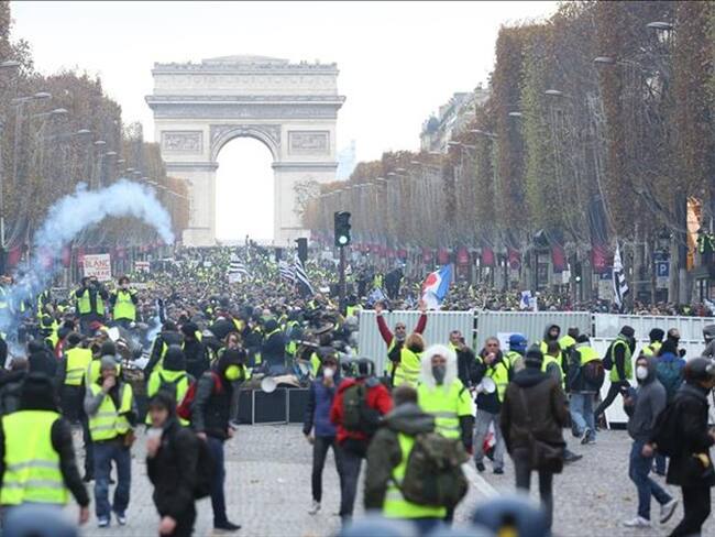 Los manifestantes de chalecos amarillos (Gilet jaune) se enfrentan a la policía antidisturbios durante una protesta contra el aumento del precio del petróleo en los Campos Elíseos en París, Francia. Foto: Agencia Anadolu