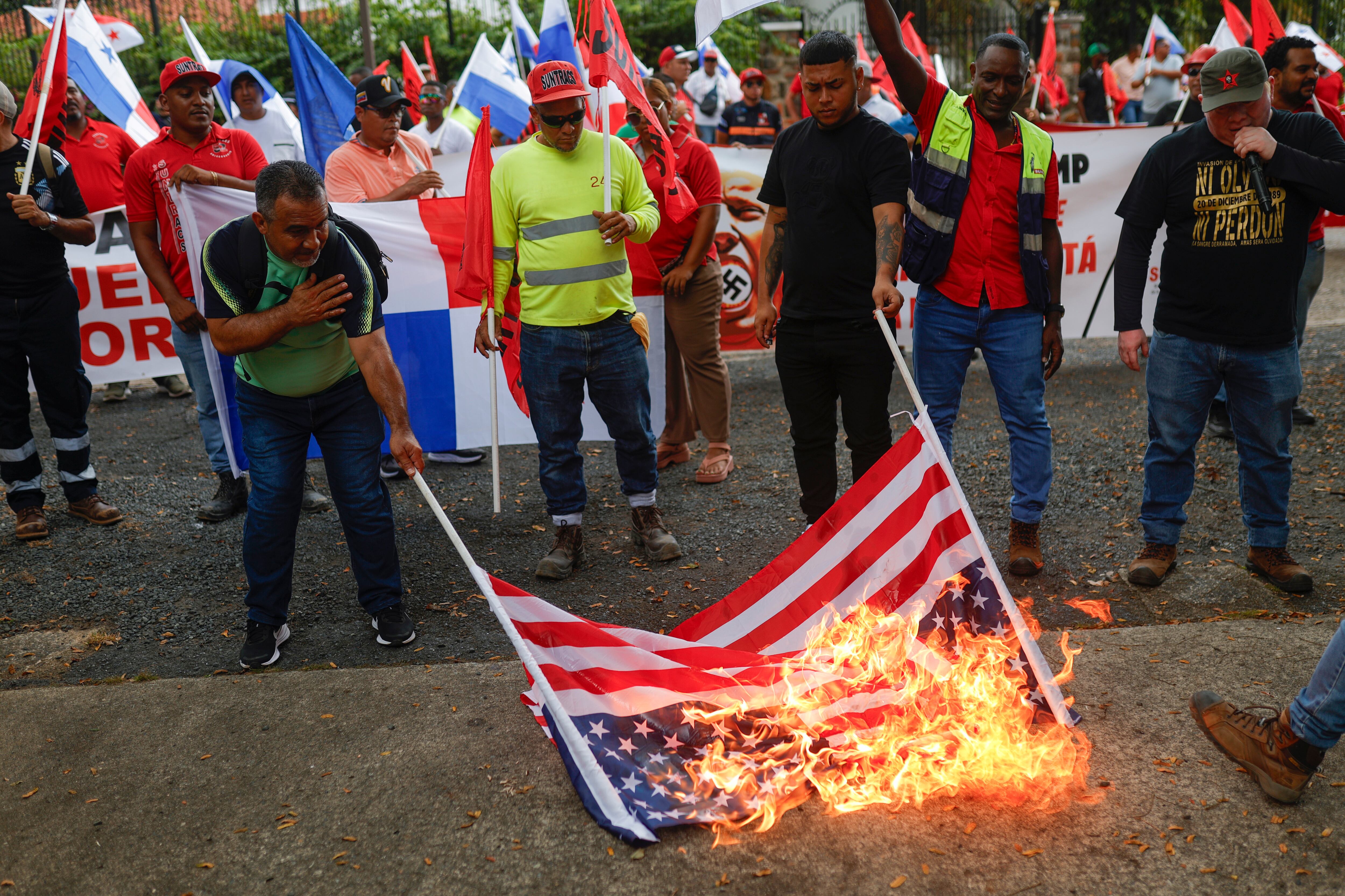 Personas queman una bandera de los Estados Unidos en una protesta de sindicalistas contra de Donald Trump. FOTO: EFE/ Bienvenido Velasco