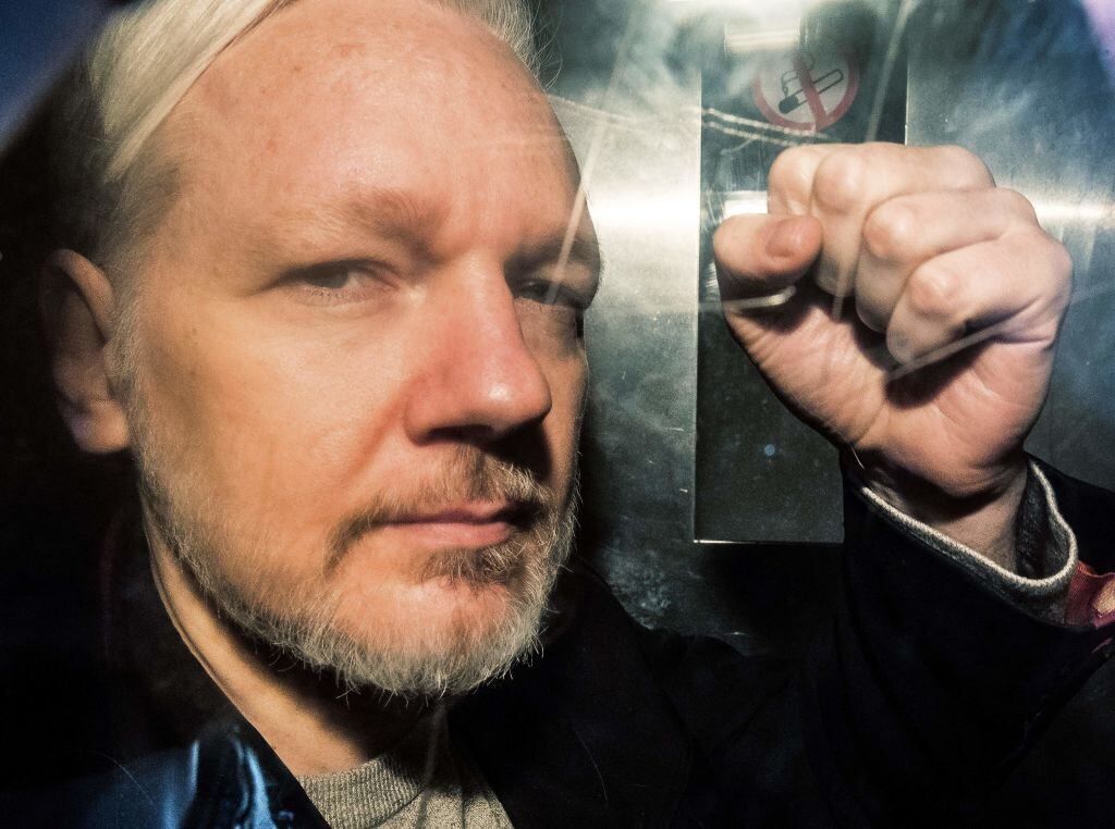 WikiLeaks founder Julian Assange gestures from the window of a prison van as he is driven into Southwark Crown Court in London on May 1, 2019, before being sentenced to 50 weeks in prison for breaching his bail conditions in 2012. (Photo by Daniel LEAL / AFP) (Photo by DANIEL LEAL/AFP via Getty Images)
