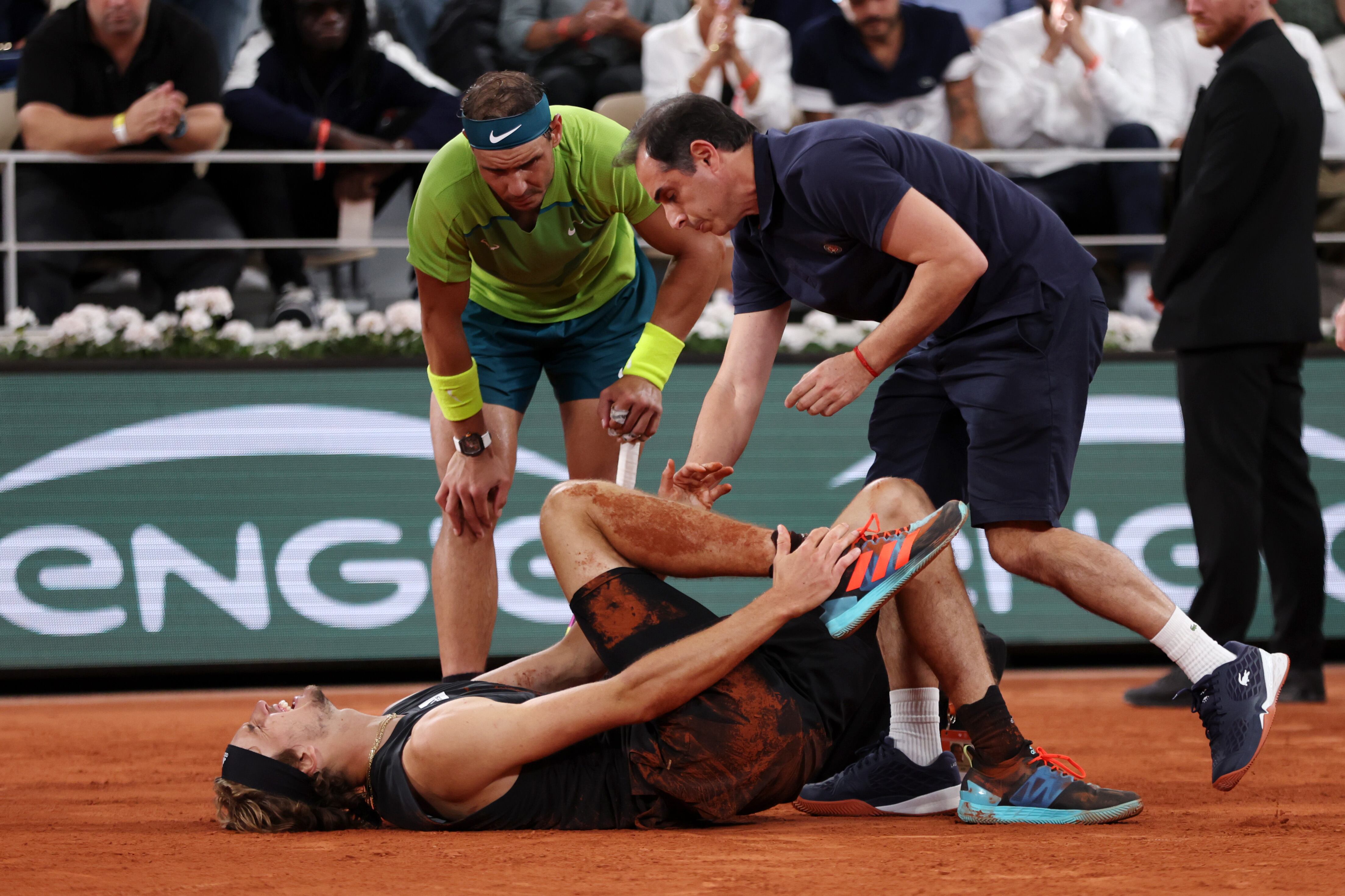 PARIS, FRANCE - JUNE 03: Rafael Nadal of Spain checks on Alexander Zverev of Germany as he receives medical attention following an injury against Rafael Nadal of Spain during the Men's Singles Semi Final match on Day 13 of The 2022 French Open at Roland Garros on June 03, 2022 in Paris, France. (Photo by Clive Brunskill/Getty Images)