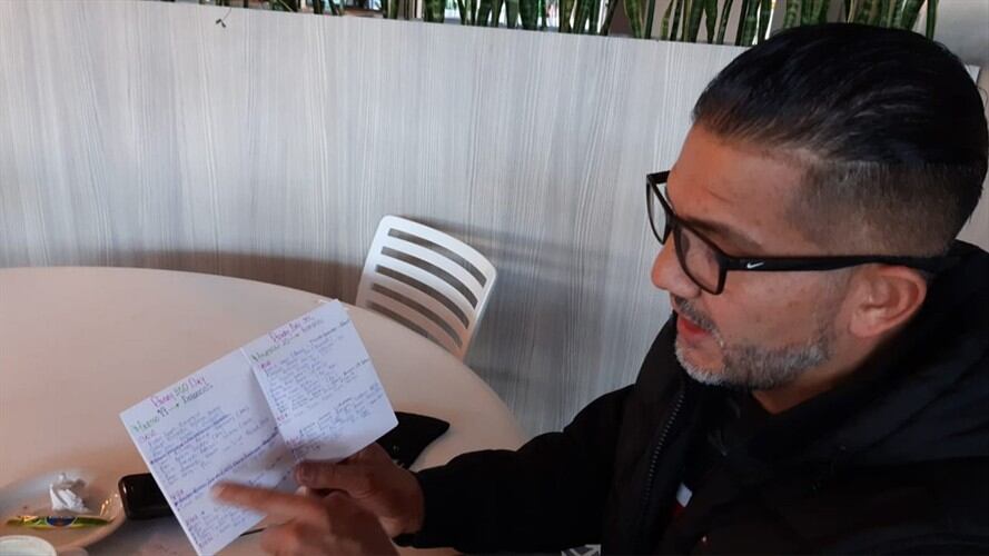 El padre Víctor, tiene ojeras pronunciadas, se sienta, en la mesa tiene una carpeta repleta de hojas escritas con cientos de peticiones.. Foto: W