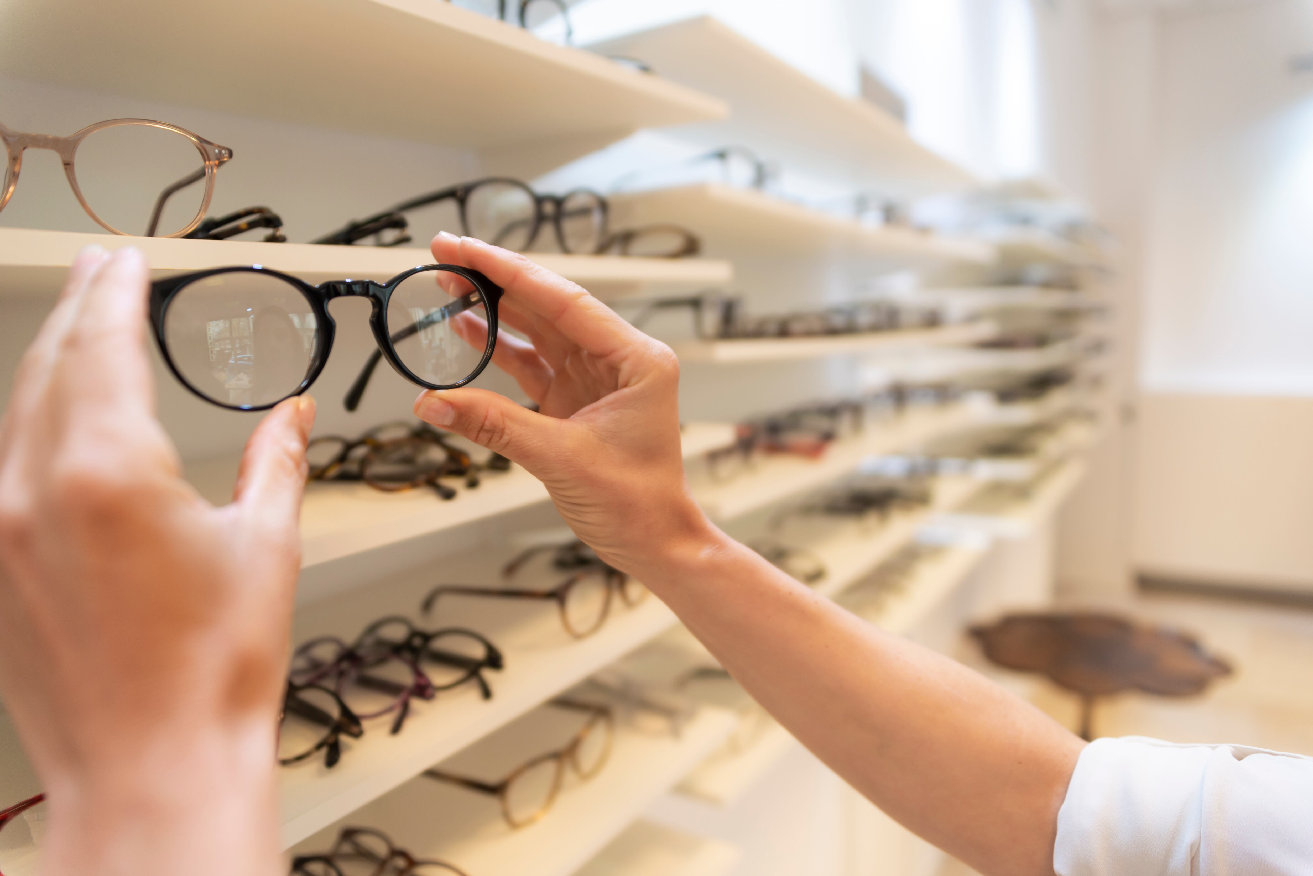 Persona escogiendo gafas en una óptica (GettyImages)