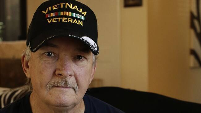 Mike Baughman sostiene una fotografía de sí mismo en 1971 vestido con su uniforme del ejército de Estados Unidos, en su casa en Danville, California. Foto: Associated Press - AP - Ben Margot