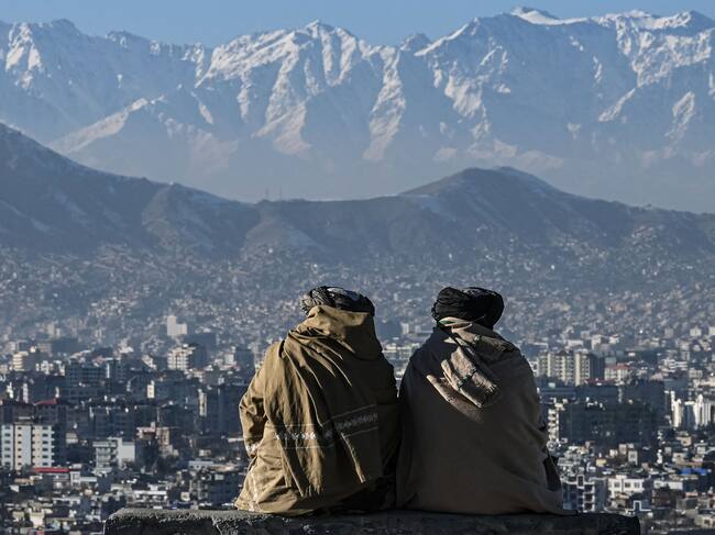 Members of the Taliban sit overlooking the Kabul city at the Wazir Akbar Khan hill in Kabul on January 20, 2022. (Photo by Mohd RASFAN / AFP) (Photo by MOHD RASFAN/AFP via Getty Images)