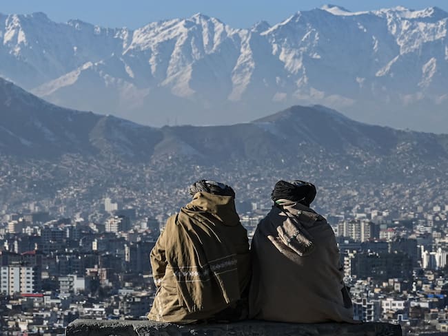 Members of the Taliban sit overlooking the Kabul city at the Wazir Akbar Khan hill in Kabul on January 20, 2022. (Photo by Mohd RASFAN / AFP) (Photo by MOHD RASFAN/AFP via Getty Images)