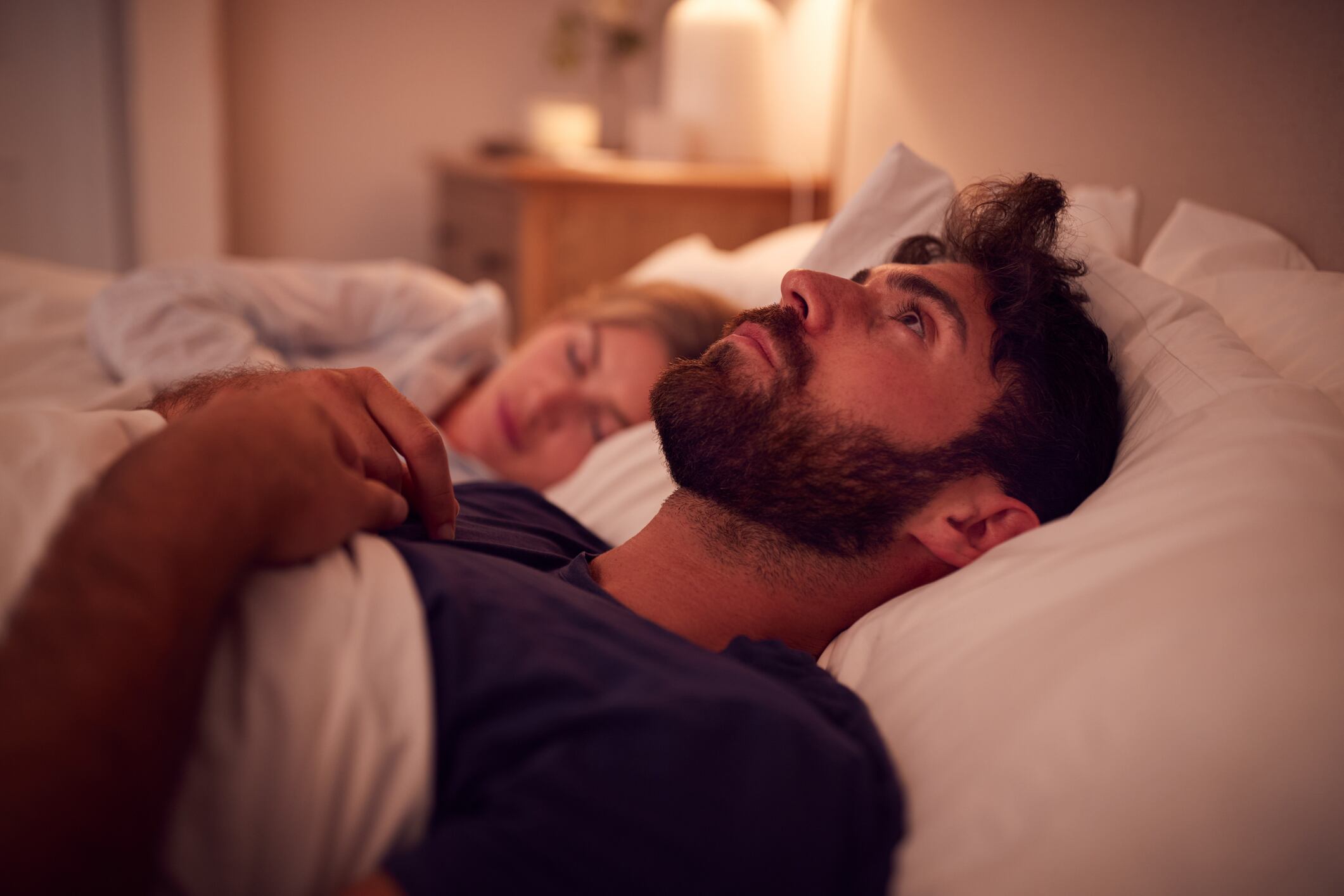 Hombre que sufre de insomnio, mientras su pareja duerme a su lado (Getty Images)