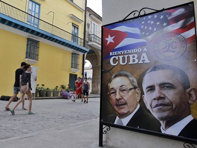 Transeúntes caminan cerca a una imagen de los presidentes de Estados Unidos, Barack Obama y Cuba, Raúl Castro. Foto: Agencia EFE