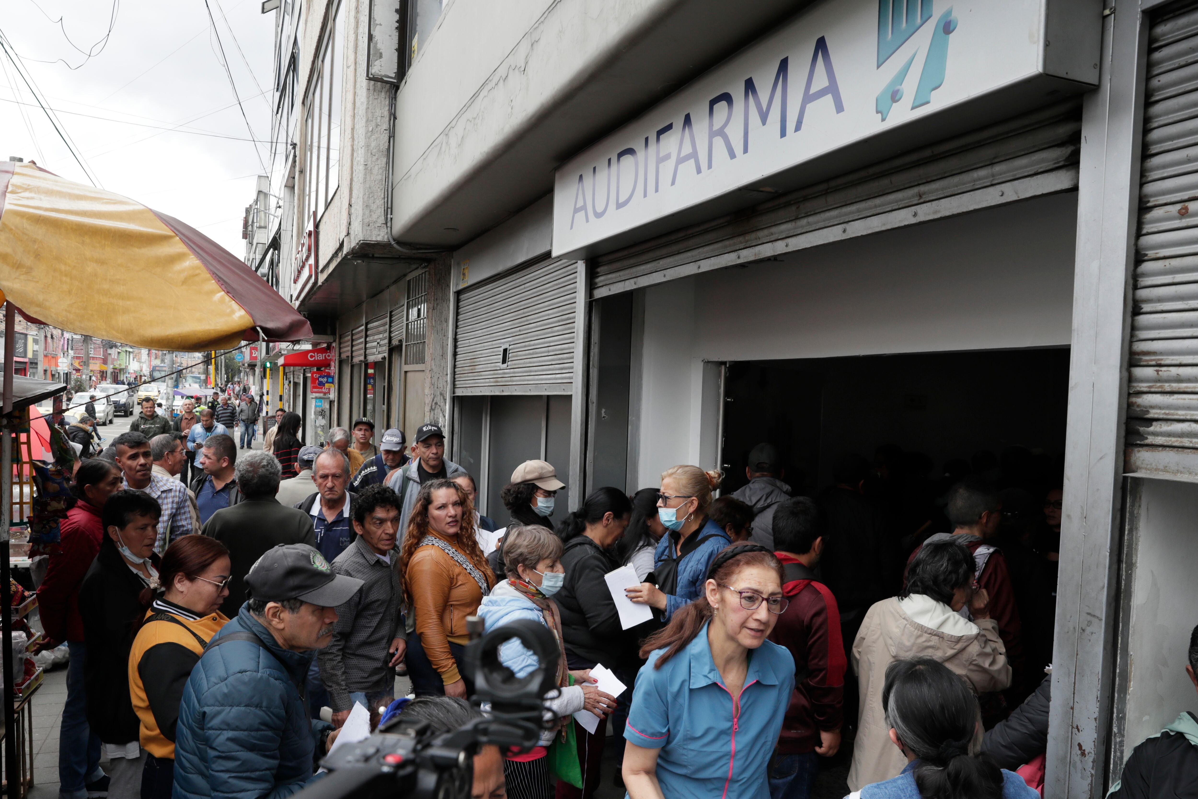 Personas hacen fila para reclamar medicamentos en la cadena de droguerías Audifarma este viernes, en Bogotá. Foto: EFE/ Carlos Ortega