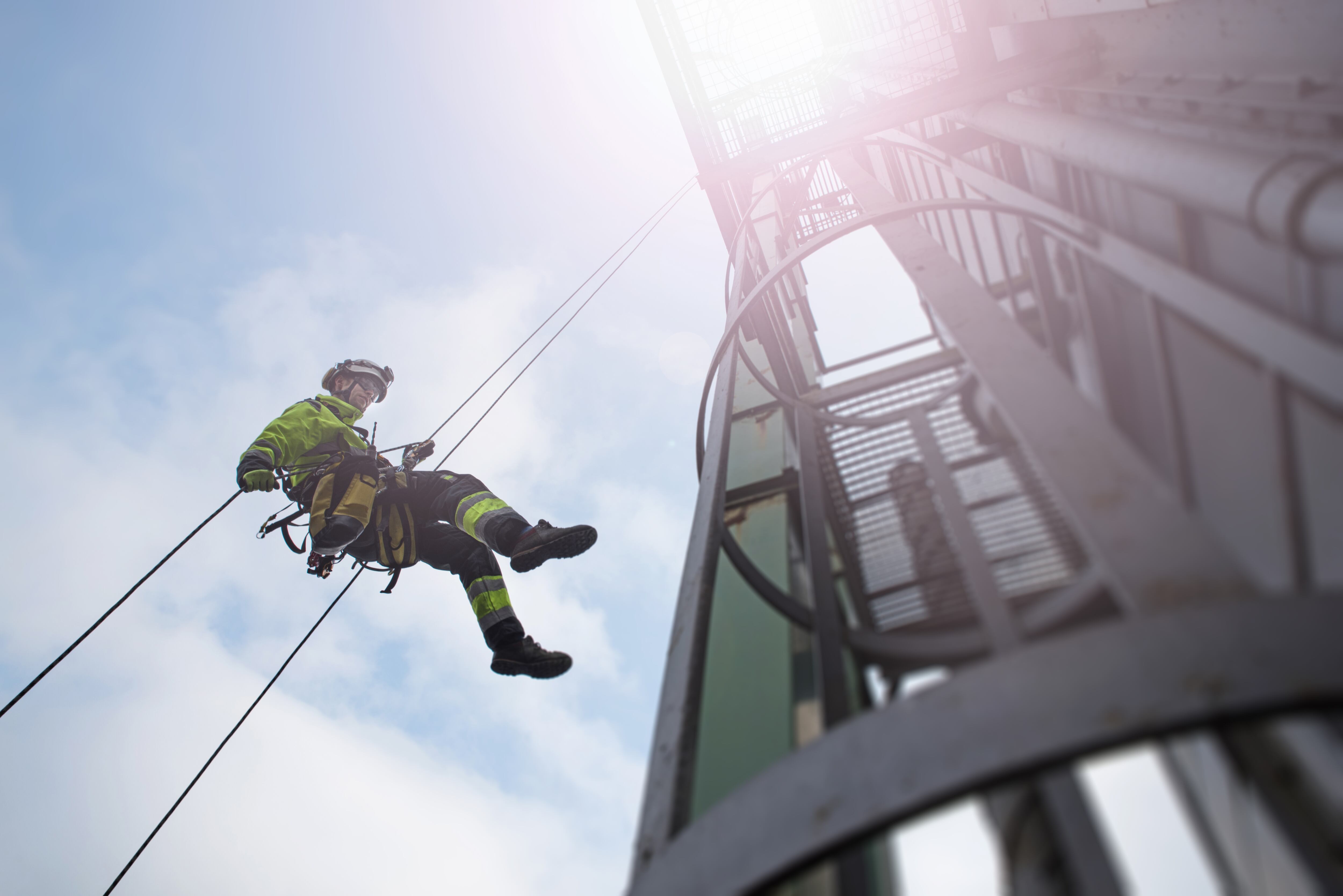 Trabajador de alturas bajando de una torre (Foto vía GettyImages)