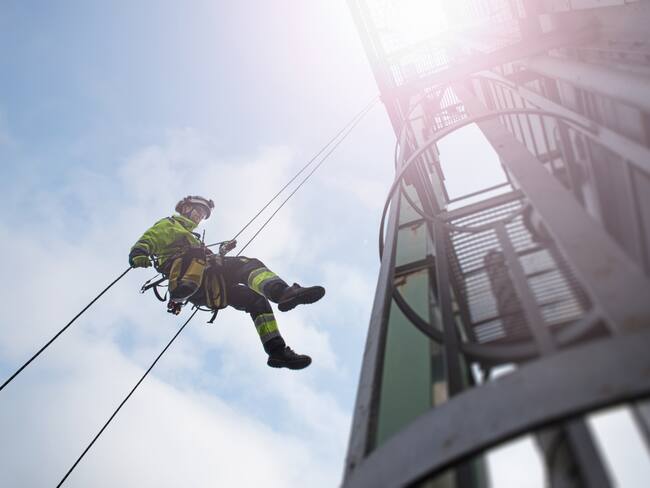 Trabajador de alturas bajando de una torre (Foto vía GettyImages)