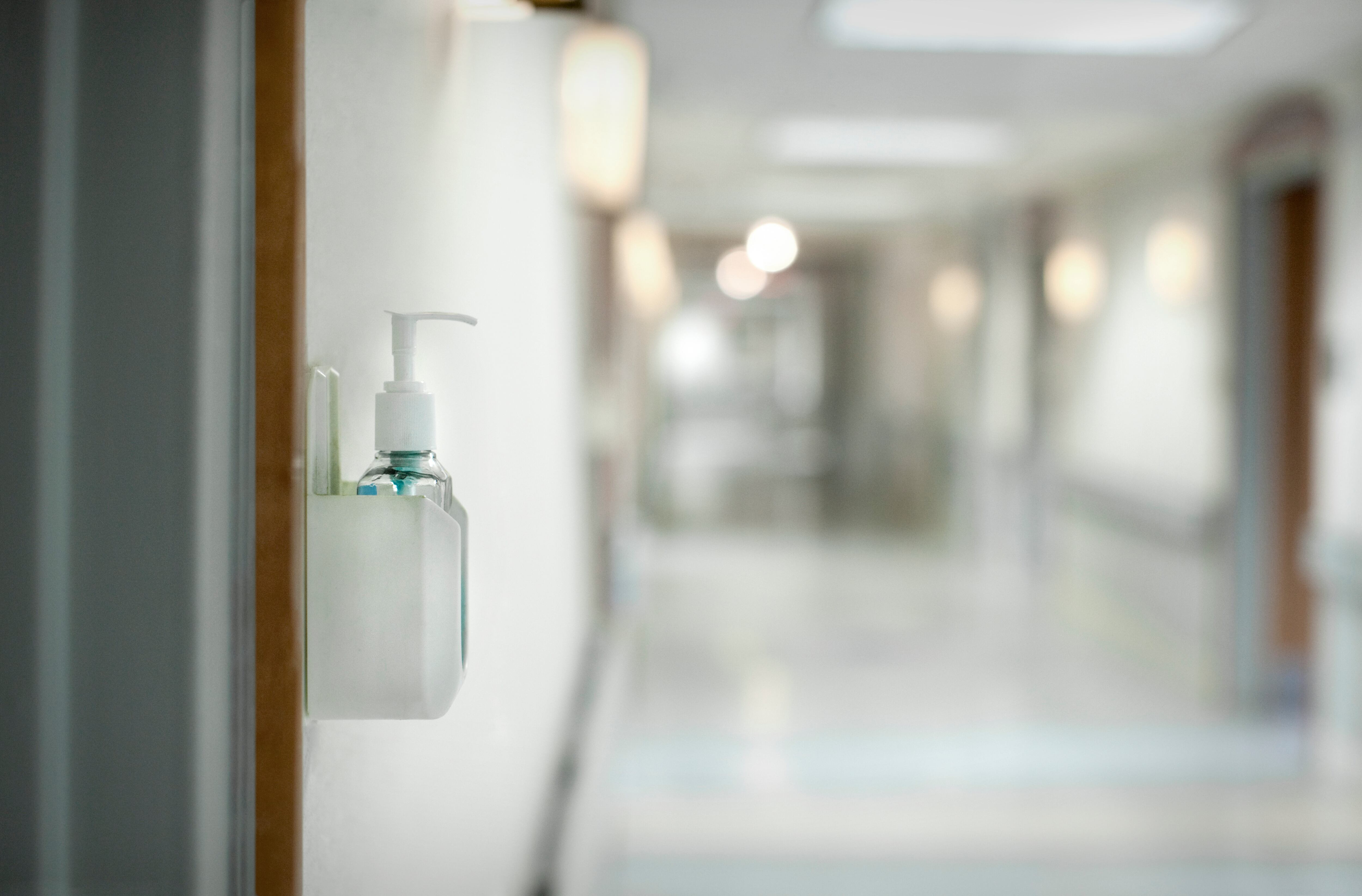 Hand sanitizer dispenser on wall of hospital in hallway