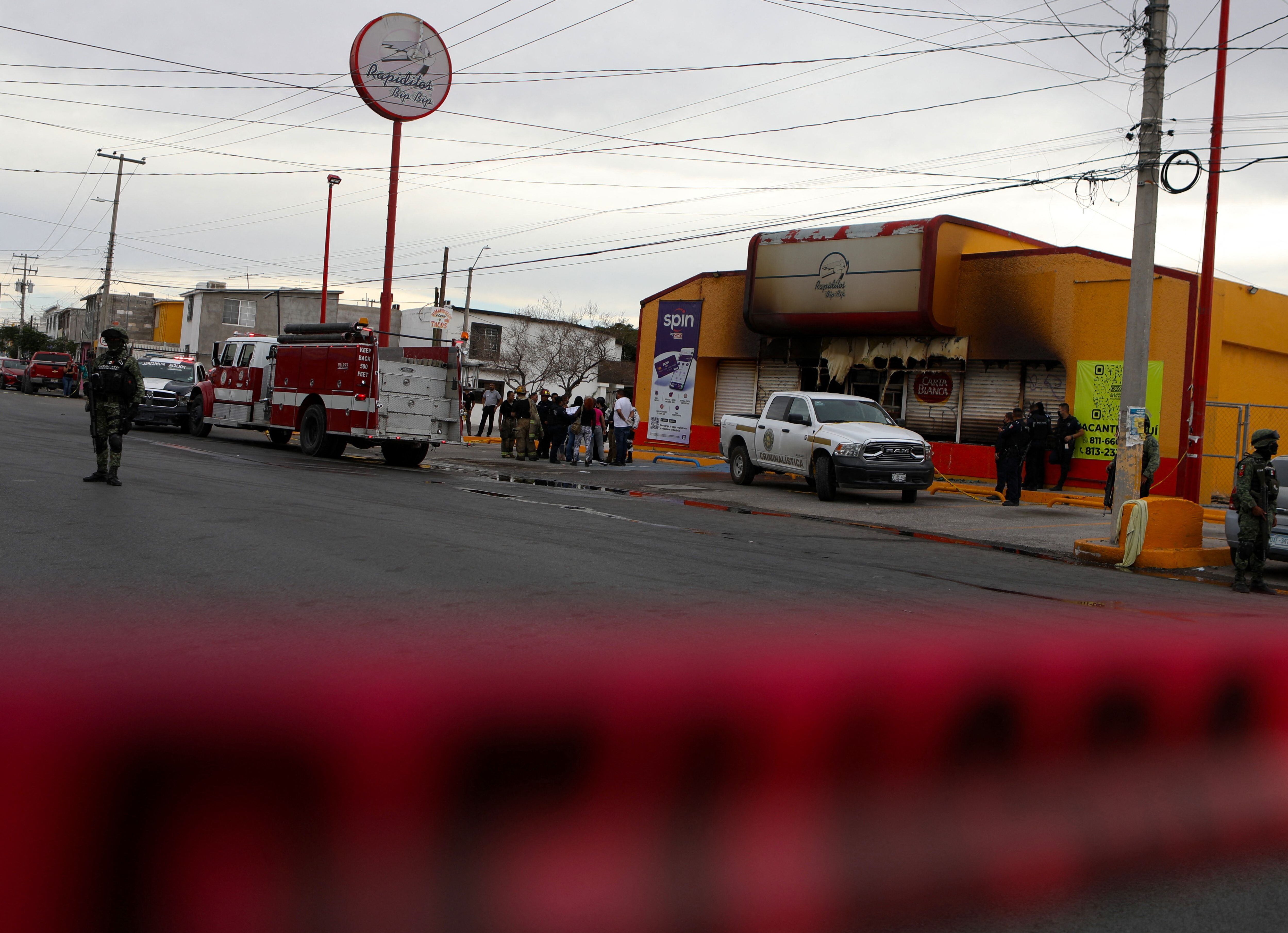 Miembros del Ejército de México, bomberos y peritos forenses trabajan en el sitio donde desconocidos incendiaron comercios en Ciudad Juárez, estado de Chihuahua, México. (Photo by HERIKA MARTINEZ/AFP via Getty Images)