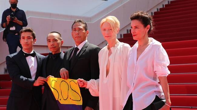 Actores de la película 'Memoria' sosteniendo bandera colombiana en la alfombra roja del Gran Teatro Lumiere en Cannes. Foto: The Film Agency
