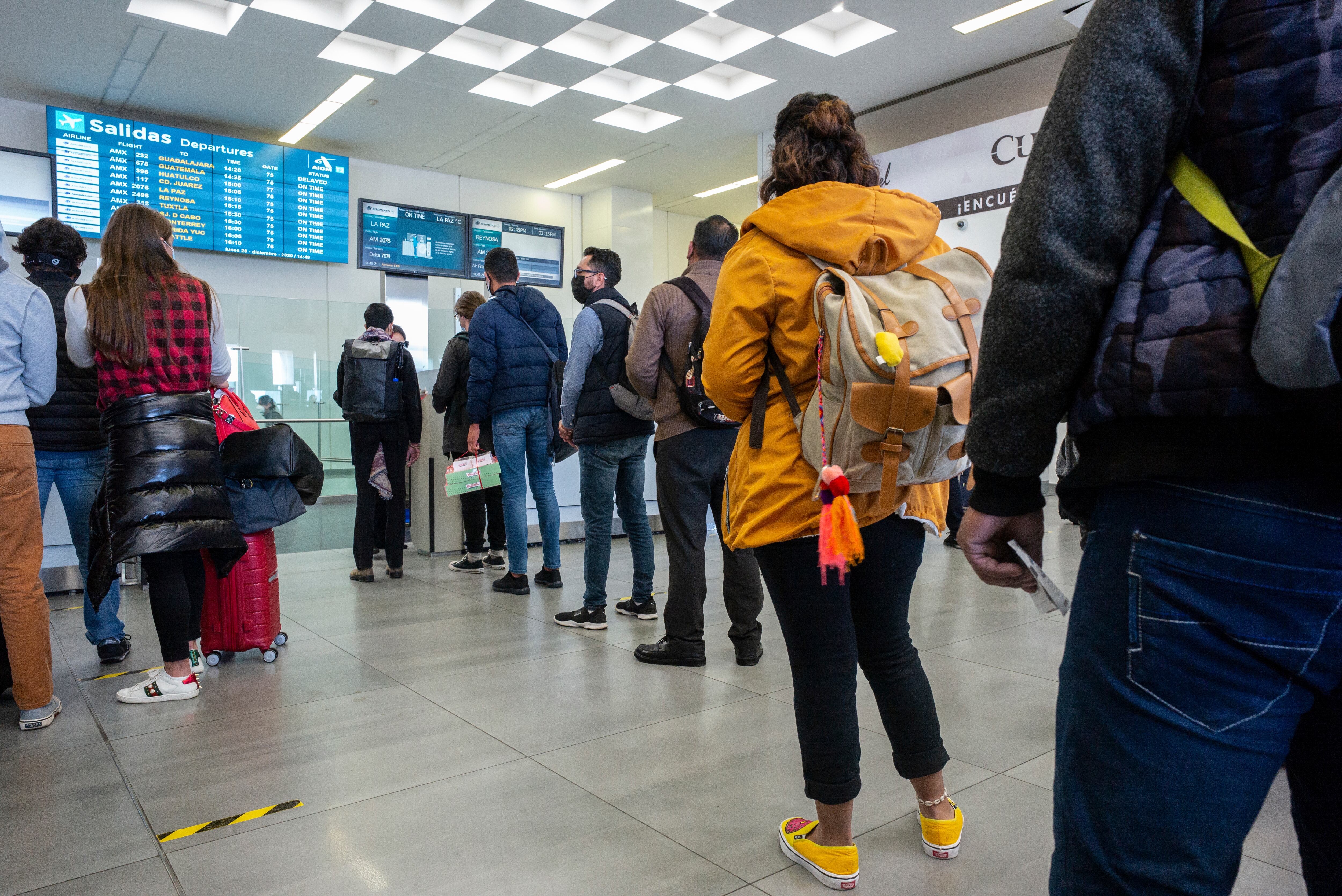 MEXICO CITY, MEXICO - DECEMBER 28: Passengers line up to board at the CDMX International airport  on December 28, 2020 in Mexico City, Mexico.  (Photo by Alfredo Martinez/Getty Images)