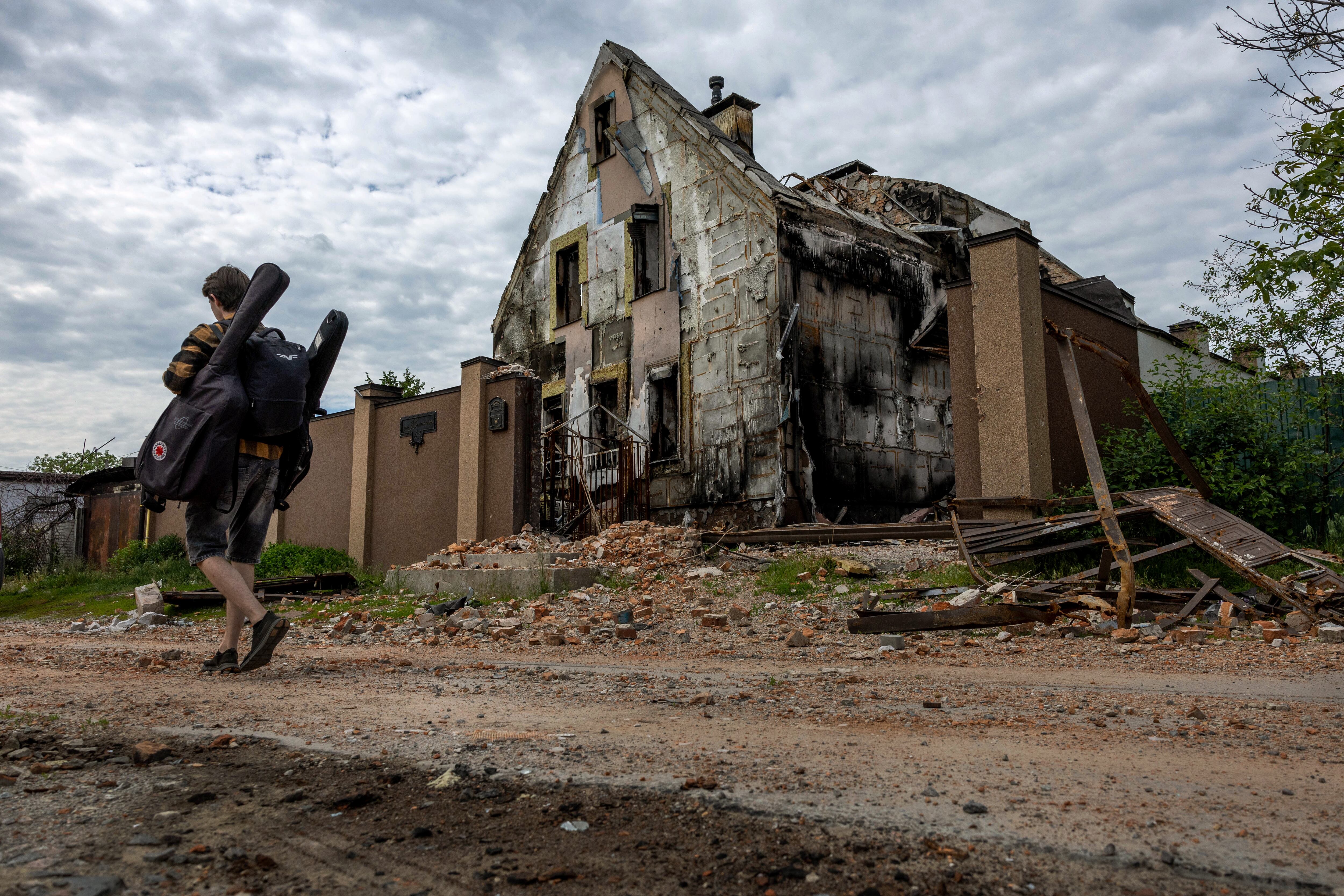 KHARKIV, UKRAINE - MAY 25: Local resident Valeriy, 25, carries guitars to a friend's apartment while moving salvageable items out of his damaged home on May 25, 2022 in Kharkiv, Ukraine. (Photo by John Moore/Getty Images)