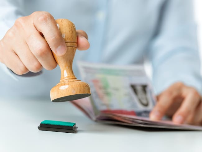 Persona aceptando la solicitud de una visa (Vía Getty Images))