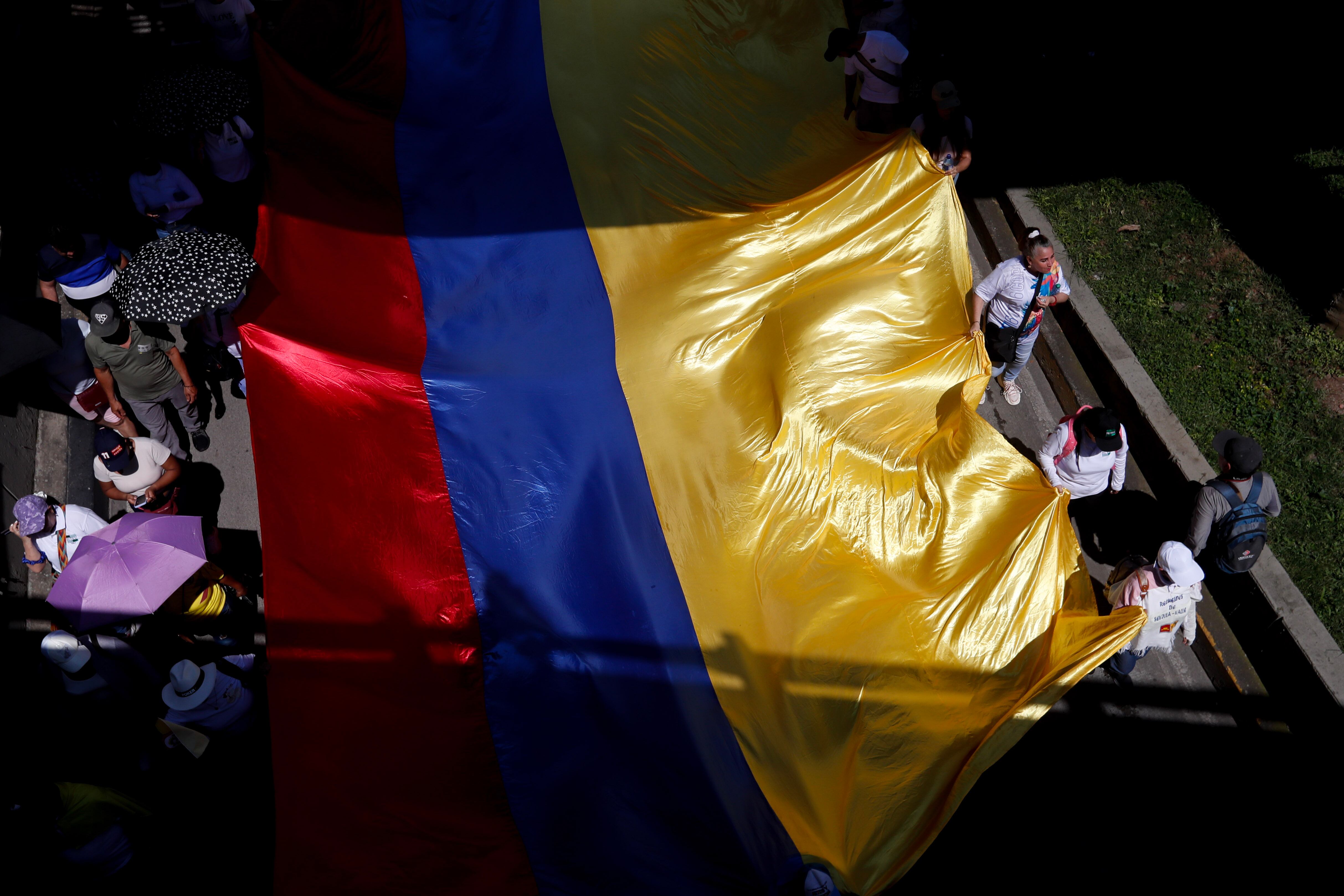 Personas sostienen una bandera de Colombia. EFE / Ernesto Guzmán