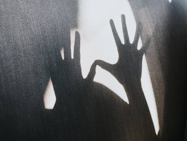 Defensive outstretched hands creating a shadow. Conceptual with space for copy.