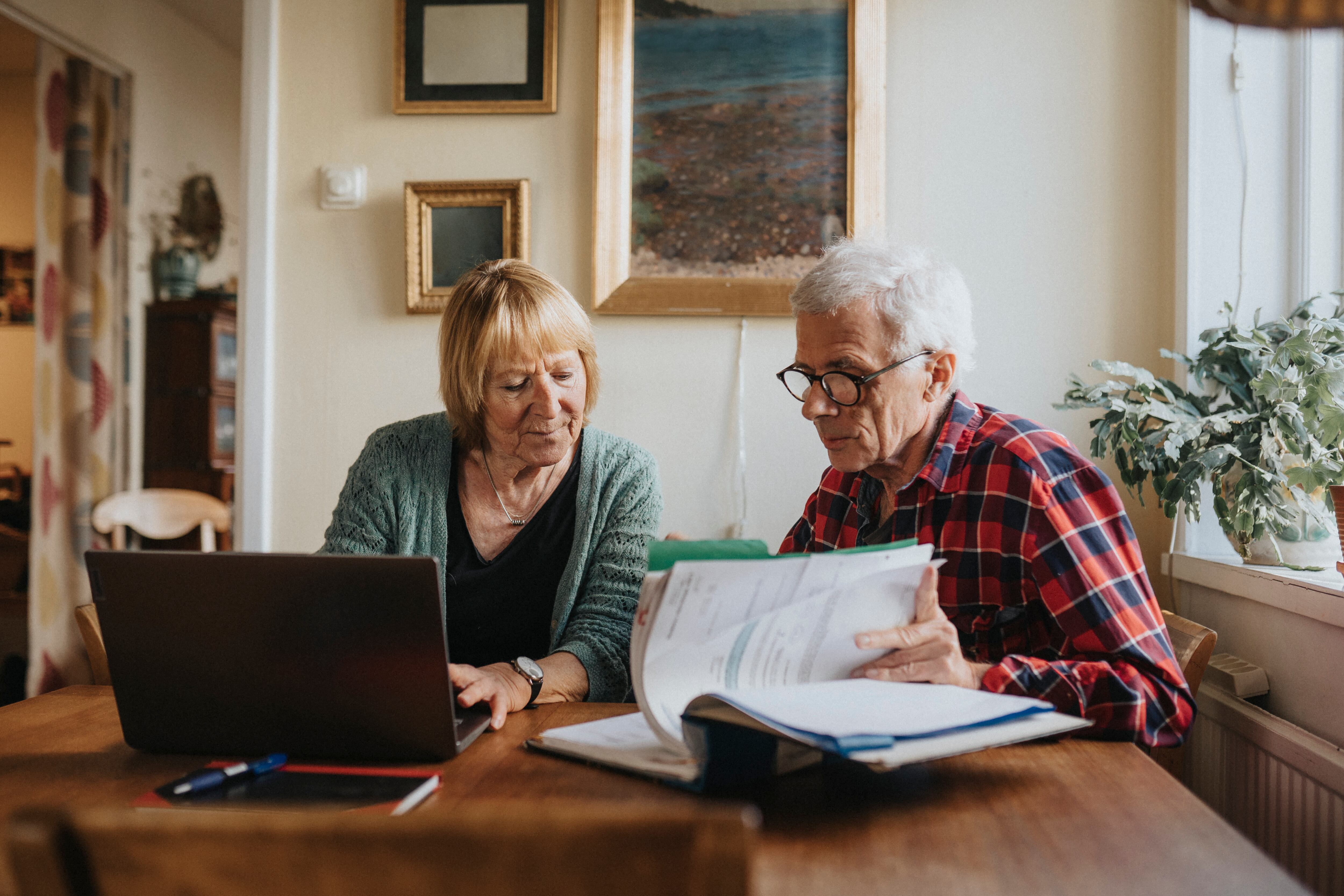 Pareja de adultos mayores usando computador para revisar su pensión (Foto vía GettyImages)