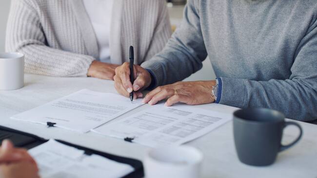 Pareja firmando un seguro de vida (Foto vía GettyImages)
