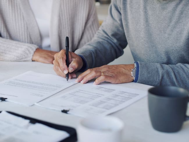 Pareja firmando un seguro de vida (Foto vía GettyImages)