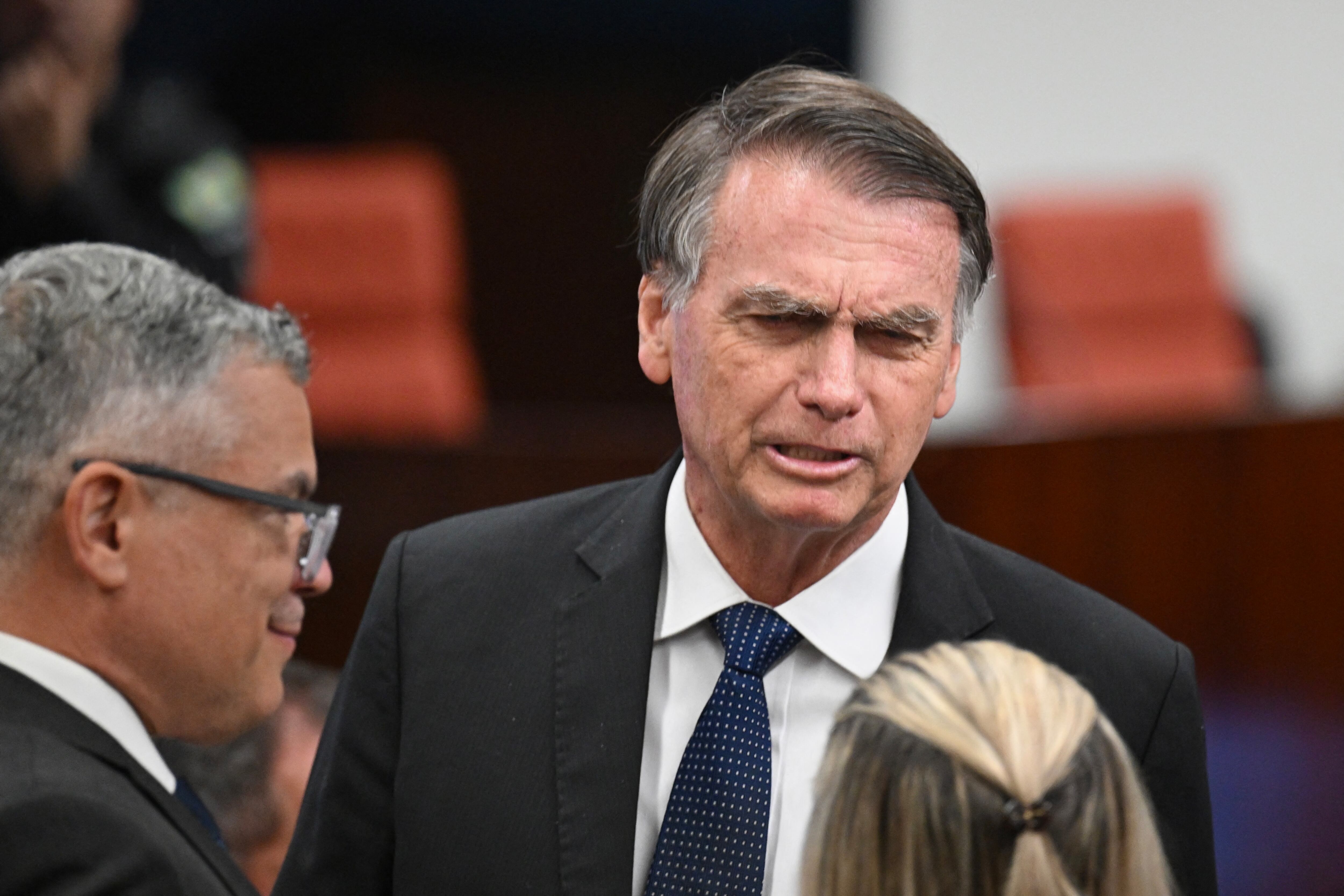 Former Brazilian President Jair Bolsonaro talks to his lawyers during his Supreme Court trial for allegedly plotting a coup in January 2023, in Brasilia, June 10, 2025. Bolsonaro on Tuesday denied any involvement in an alleged coup plot, as he took the stand for the first time in his high-stakes trial. The 70-year-old is answering questions from lawyers and judges on his alleged role in a "criminal organization" that plotted to wrest power from leftist Luiz Inacio Lula da Silva, who narrowly beat Bolsonaro at the ballot box in 2022. Bolsonaro was the sixth of eight accused to take the stand for in-person questioning that started on Monday. (Photo by Evaristo SA / AFP) (Photo by EVARISTO SA/AFP via Getty Images)          