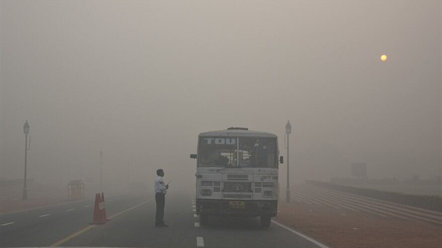 Un policía de tráfico de Delhi habla con un conductor de autobús en una intersección en medio del humo y el smog, en la mañana tras el festival de Diwali en Nueva Delhi, India. Foto: Associated Press - AP - Manish Swarup