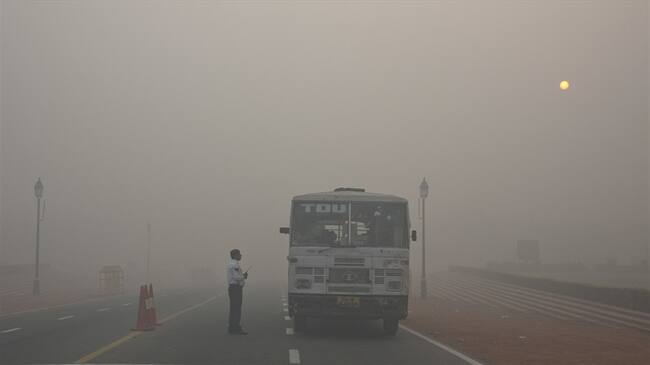 Un policía de tráfico de Delhi habla con un conductor de autobús en una intersección en medio del humo y el smog, en la mañana tras el festival de Diwali en Nueva Delhi, India. Foto: Associated Press - AP - Manish Swarup
