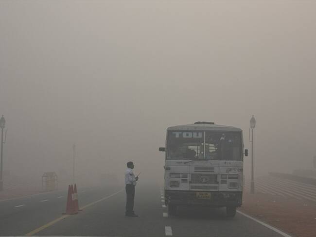 Un policía de tráfico de Delhi habla con un conductor de autobús en una intersección en medio del humo y el smog, en la mañana tras el festival de Diwali en Nueva Delhi, India. Foto: Associated Press - AP - Manish Swarup