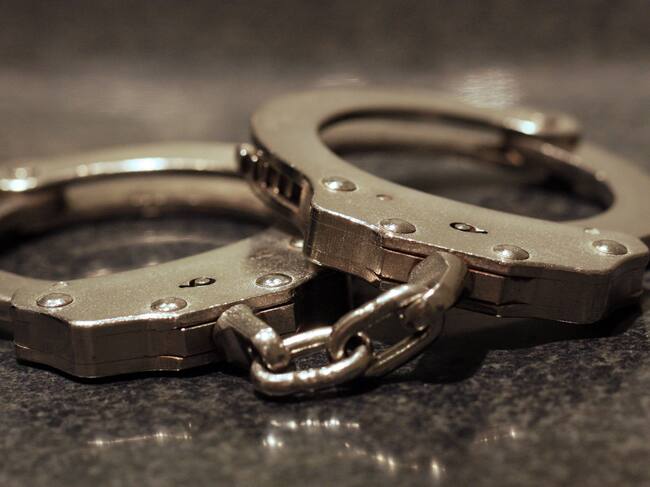 A close up shot of a pair of handcuffs on a table.