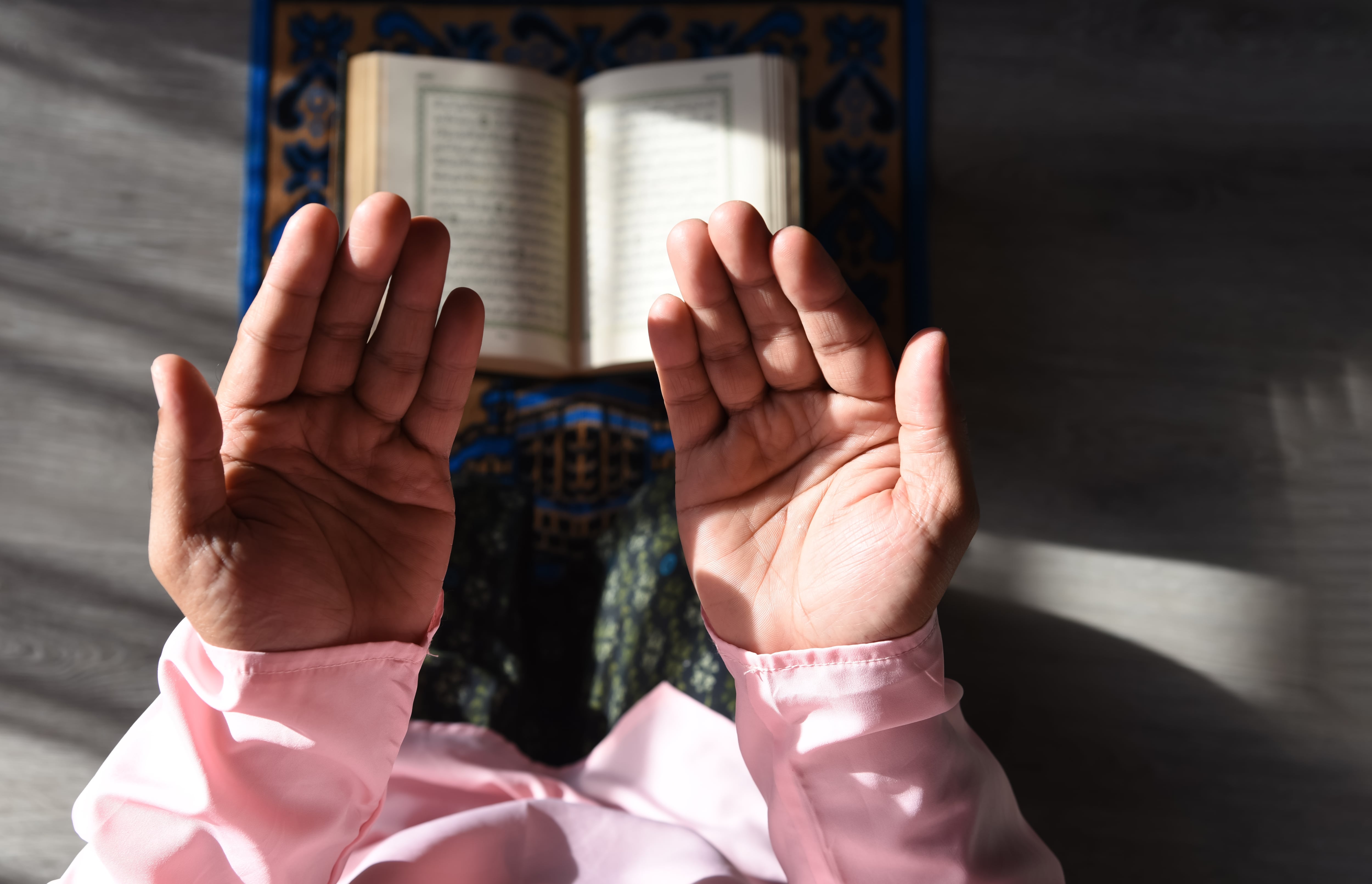 A Muslim man is praying or Salah at home.