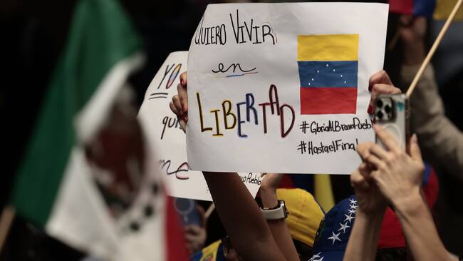 MEX9238. CIUDAD DE MÉXICO (MÉXICO), 09/01/2025.- Una persona venezolana sostiene un cartel en una manifestación este jueves frente a la embajada de Venezuela, en Ciudad de México (México). Un centenar de opositores venezolanos protestaron este jueves en la embajada de su país en México a un día de la investidura presidencial en Venezuela, que tanto el actual presidente, Nicolás Maduro, como el opositor Edmundo González Urrutia han prometido asumir. EFE/José Méndez