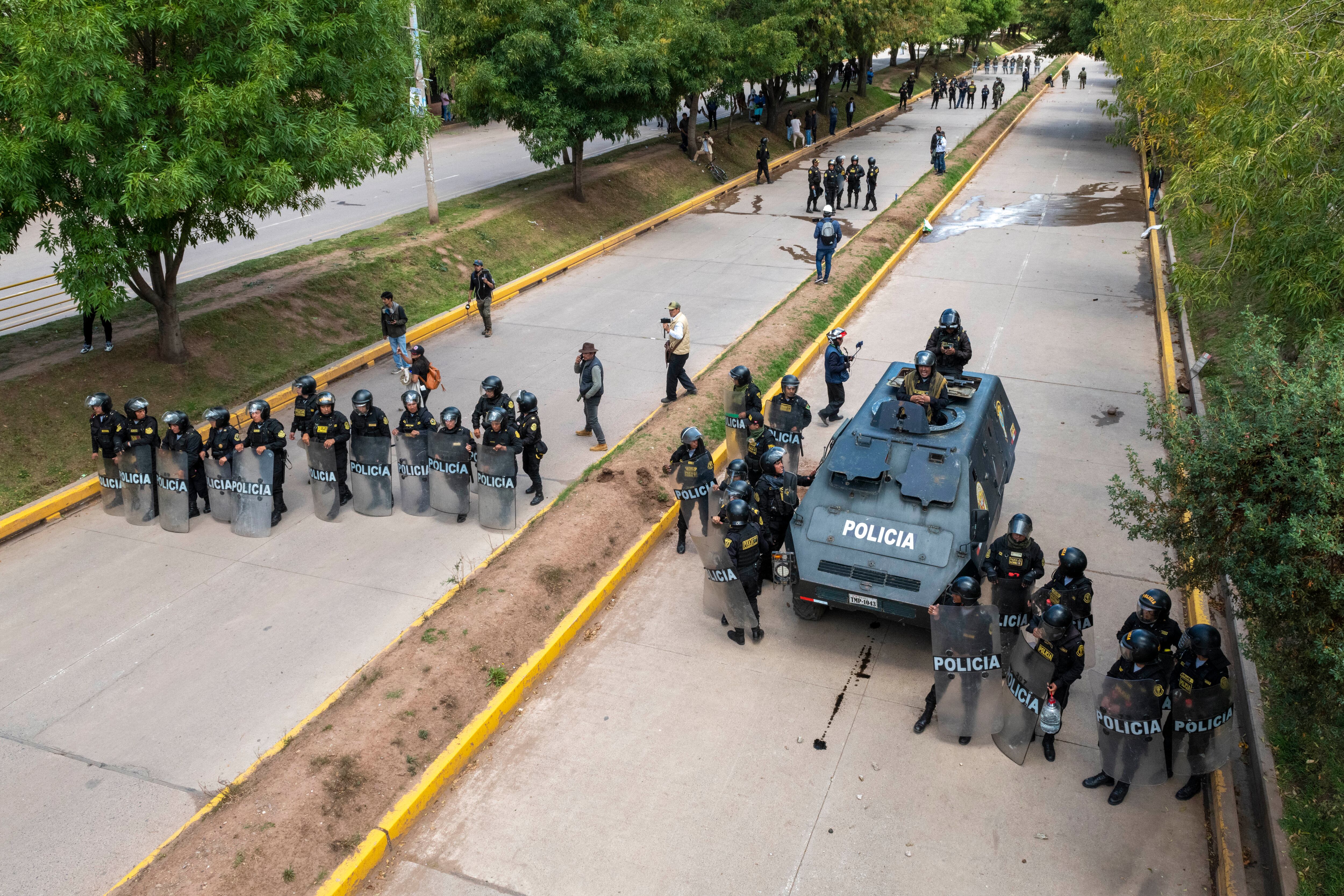 Oficiales de policía hacen guardia formando una barricada en la Avenida 28 de Julio para evitar que los manifestantes marchen hacia el Aeropuerto Internacional Alejandro Velasco Astete durante una protesta el 11 de enero de 2023 en Cusco, Perú. Foto de Michael Bednar/Getty) Imágenes.