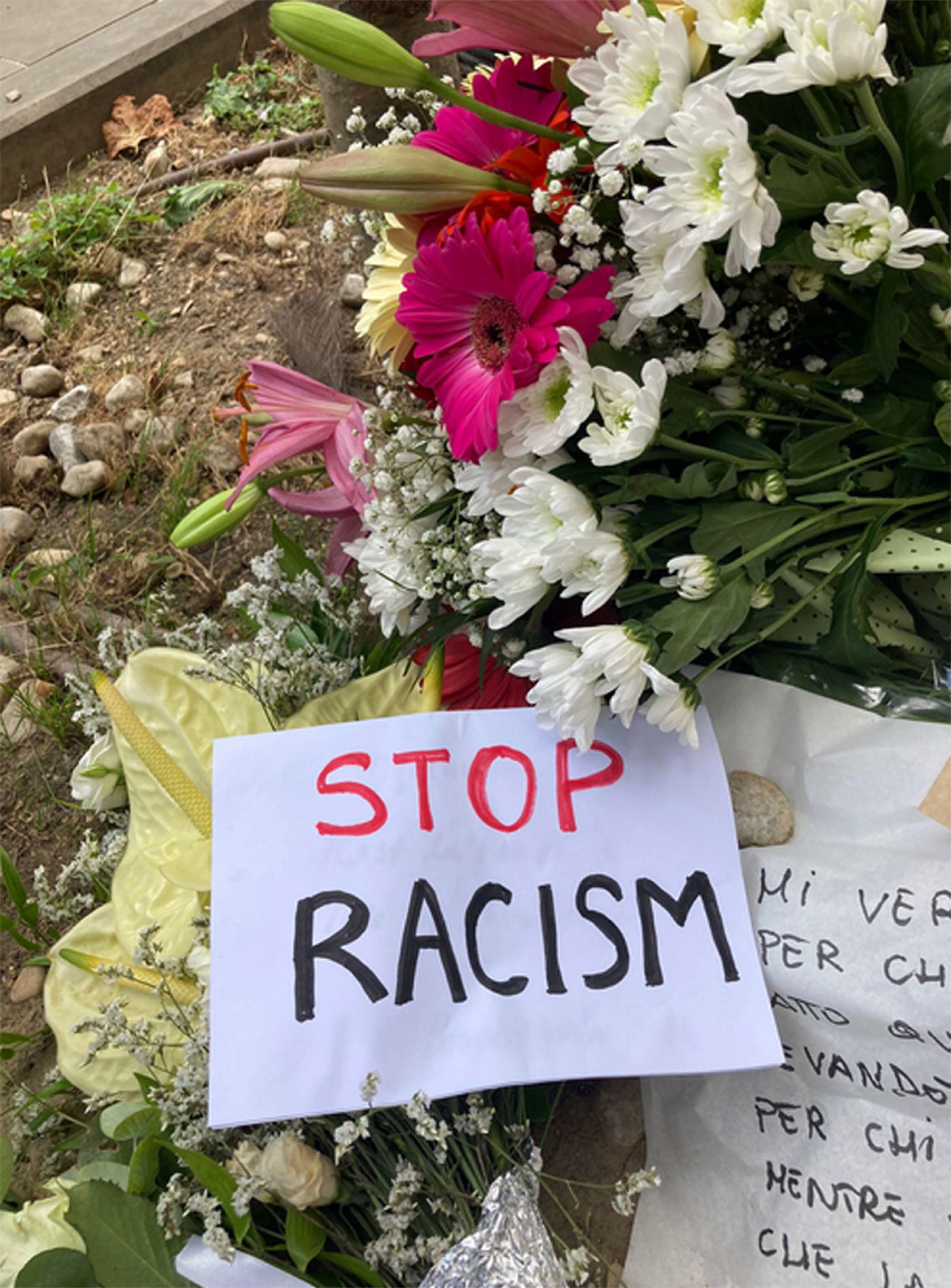 Flores y tarjetas colocadas en el lugar donde el vendedor ambulante nigeriano, Alika Ogorchukwu, fue agredido y asesinado por un italiano el 29 de julio a plena luz del día, en Civitanova Marche, Italia , 30 de julio de 2022. Foto: EFE/EPA/Stringer