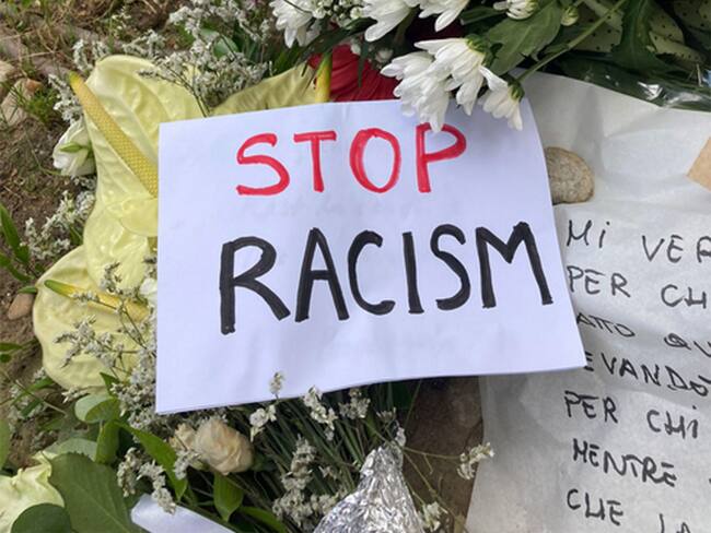 Flores y tarjetas colocadas en el lugar donde el vendedor ambulante nigeriano, Alika Ogorchukwu, fue agredido y asesinado por un italiano el 29 de julio a plena luz del día, en Civitanova Marche, Italia , 30 de julio de 2022. Foto: EFE/EPA/Stringer