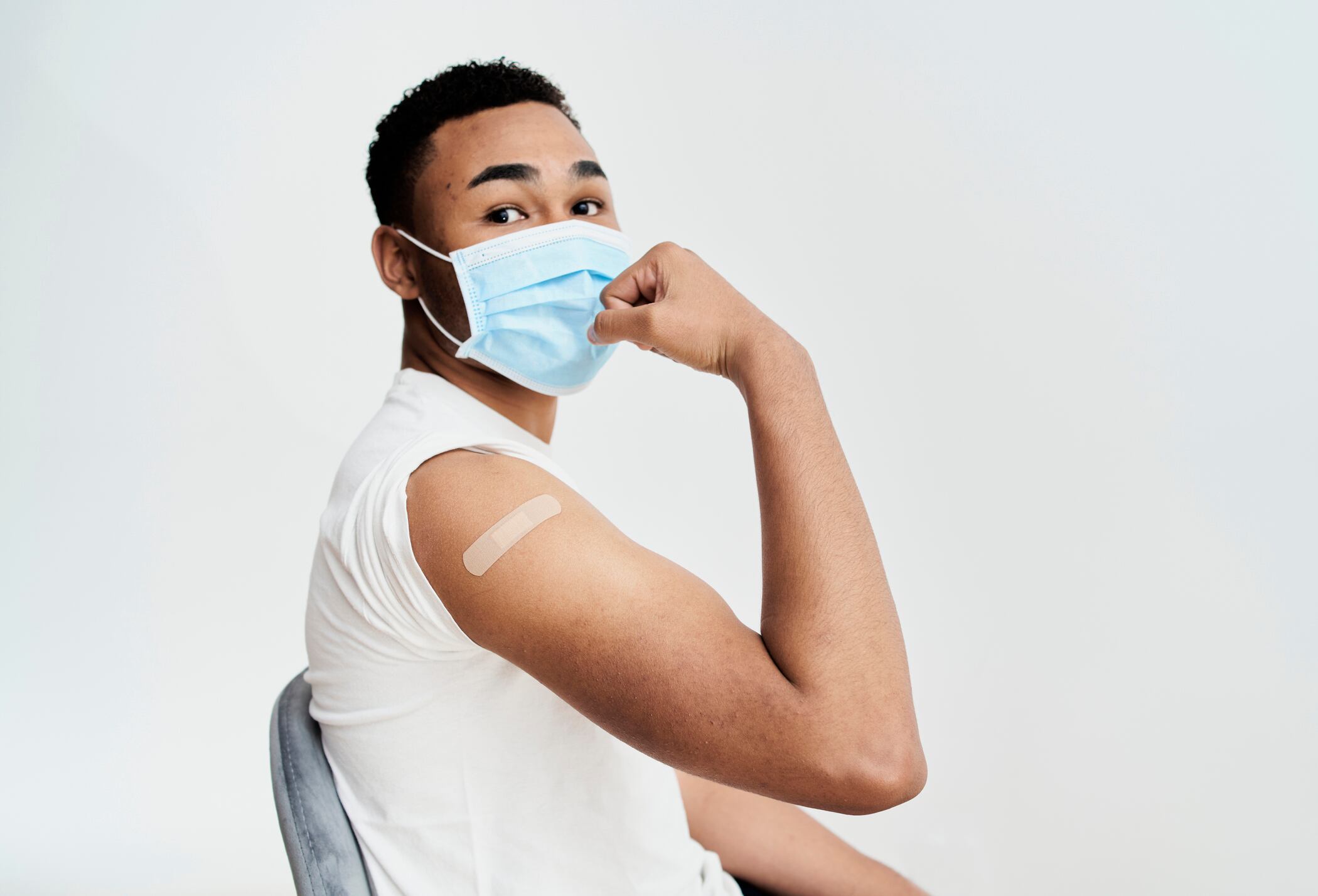 black boy shows the bandage on his arm with a gesture of strength and self-improvement and looking at camera