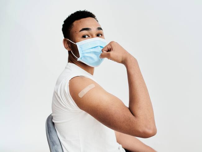 black boy shows the bandage on his arm with a gesture of strength and self-improvement and looking at camera
