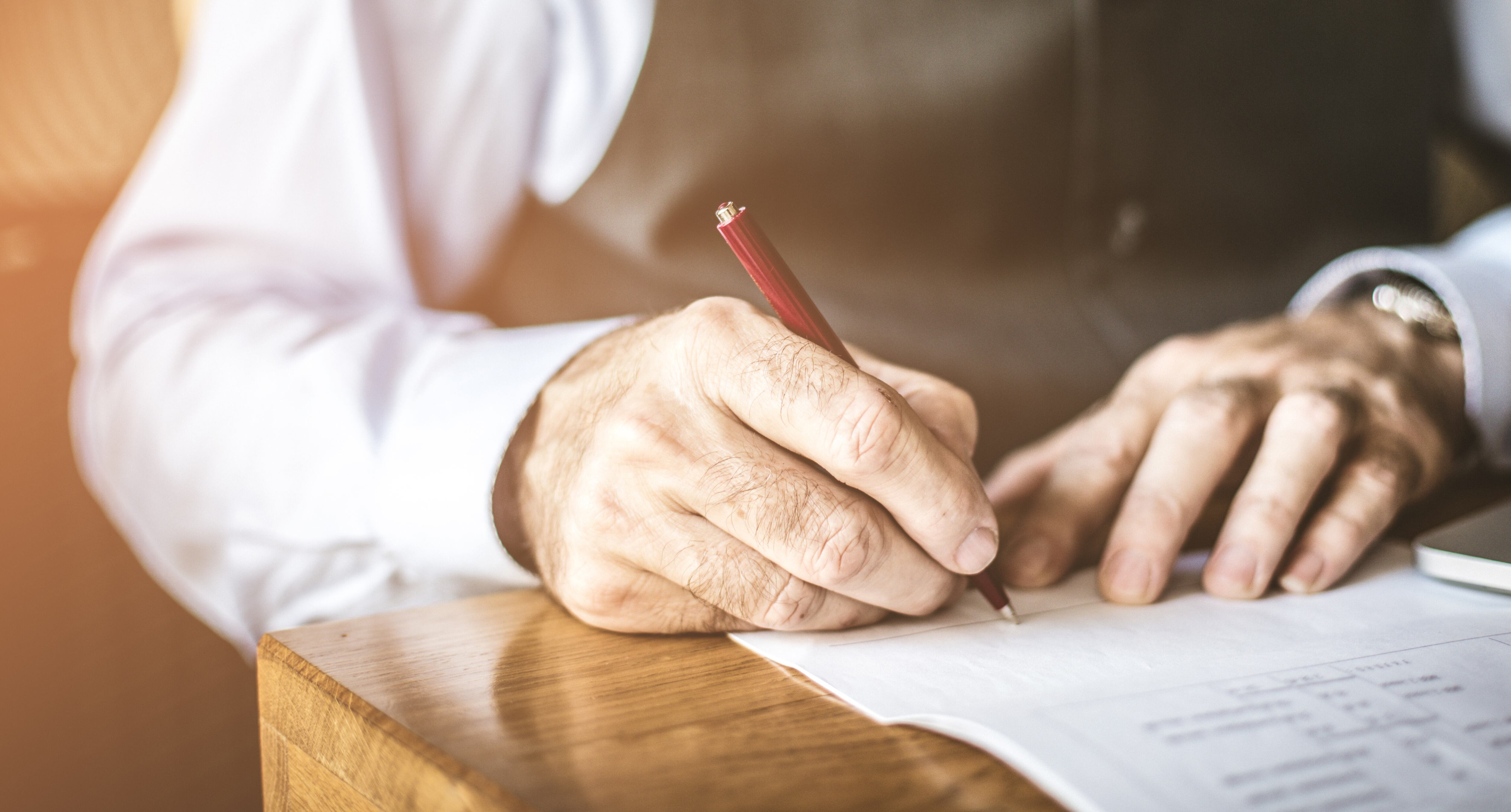 Signature. Close up image of senior businessman sign in papers.