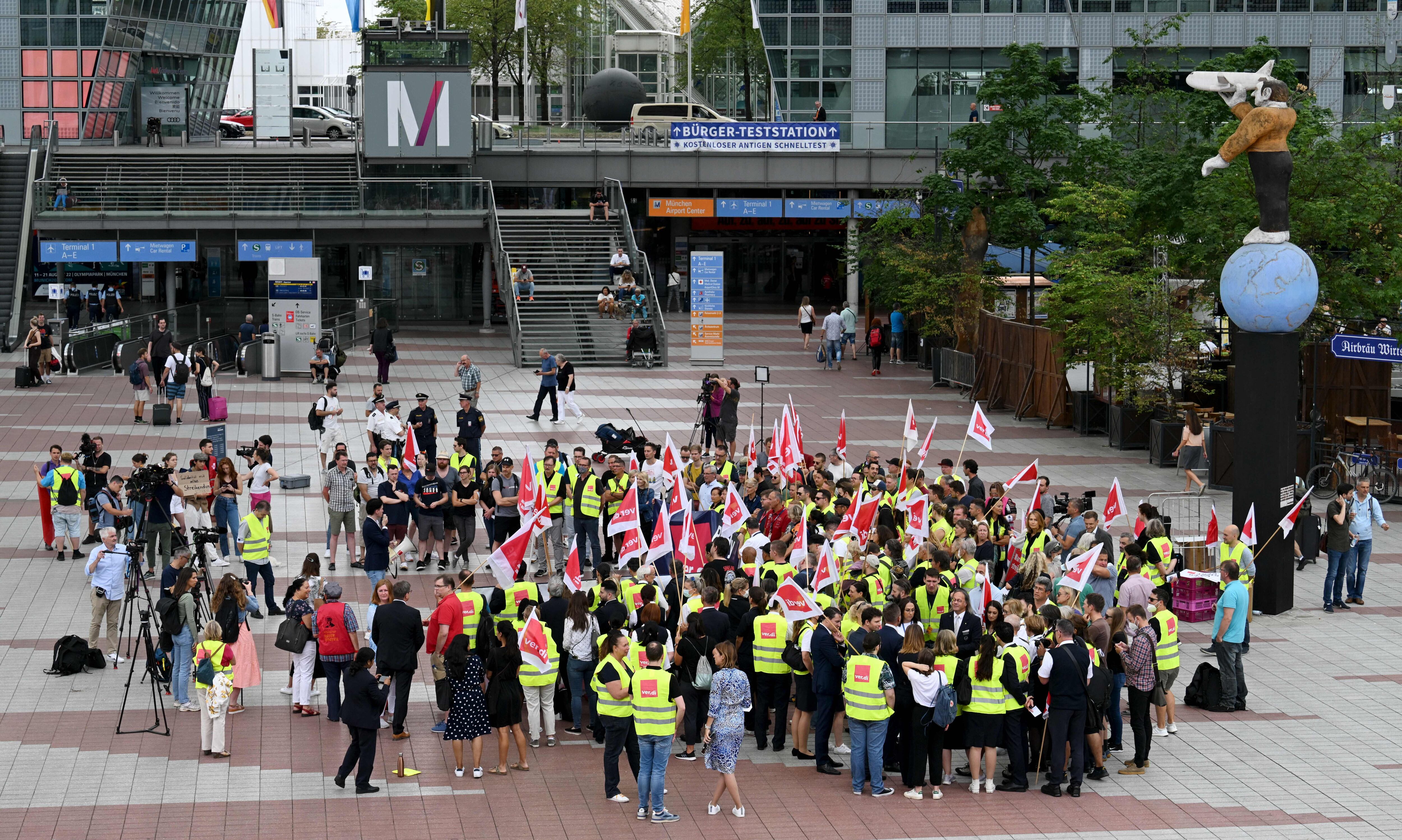 Empleados de la aerolínea alemana Lufthansa protestan frente a la terminal de Lufthansa en el aeropuerto Franz-Josef-Strauss, en Munich, este 27 de julio de 2022. (Photo by Christof STACHE / AFP) (Photo by CHRISTOF STACHE/AFP via Getty Images)