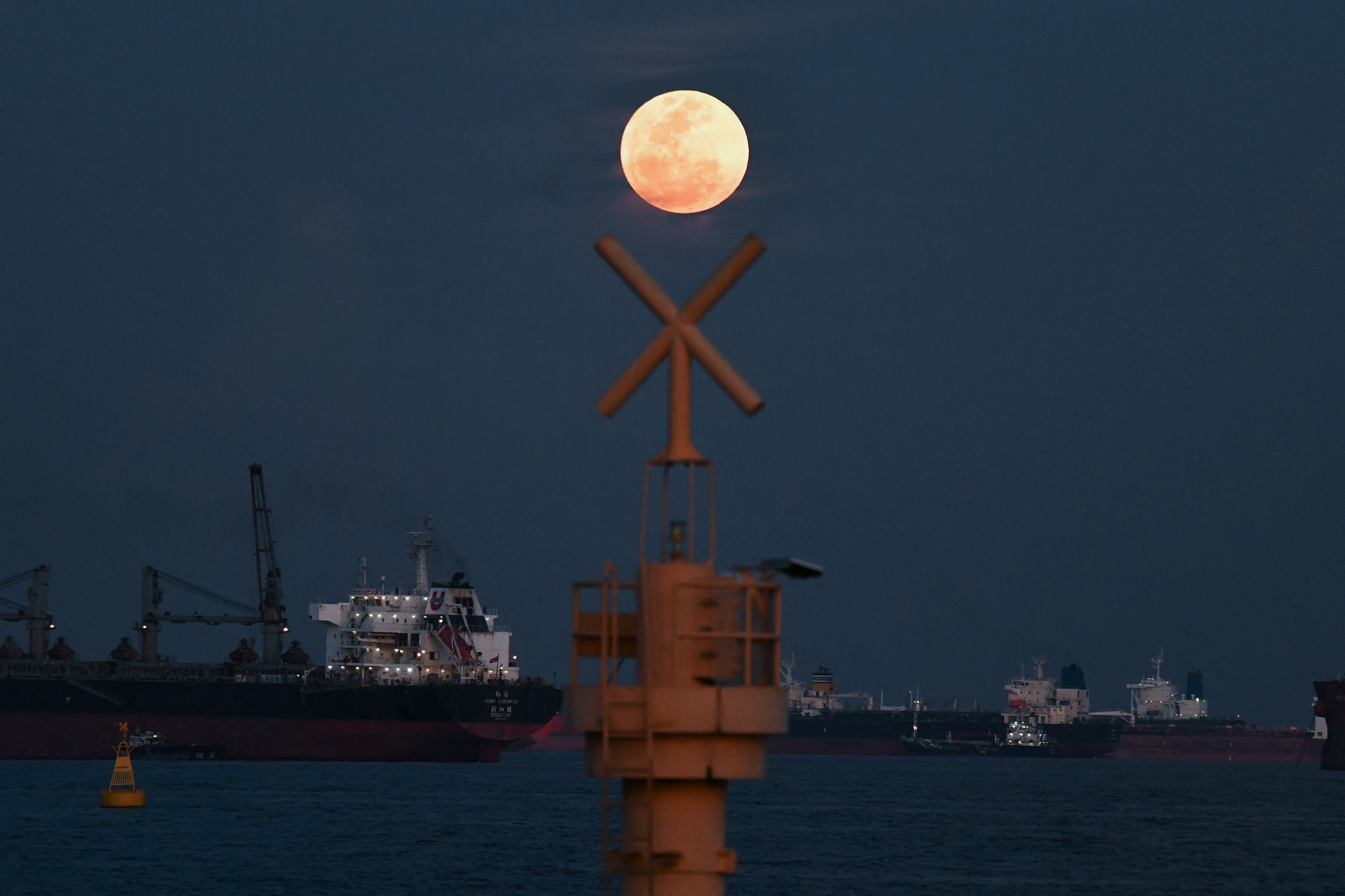 The full moon rises as the June 2022 "Strawberry Supermoon" in Singapore on June 14, 2022. (Photo by ROSLAN RAHMAN / AFP)