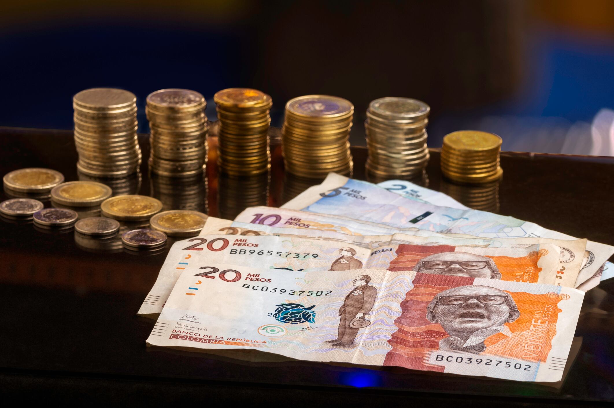 Pesos colombianos, billetes y monedas sobre una mesa (Foto vía Getty Images)
