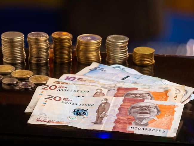 Pesos colombianos, billetes y monedas sobre una mesa (Foto vía Getty Images)